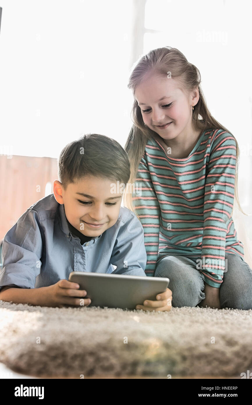 Geschwister mit digital-Tablette auf Boden zu Hause Stockfoto