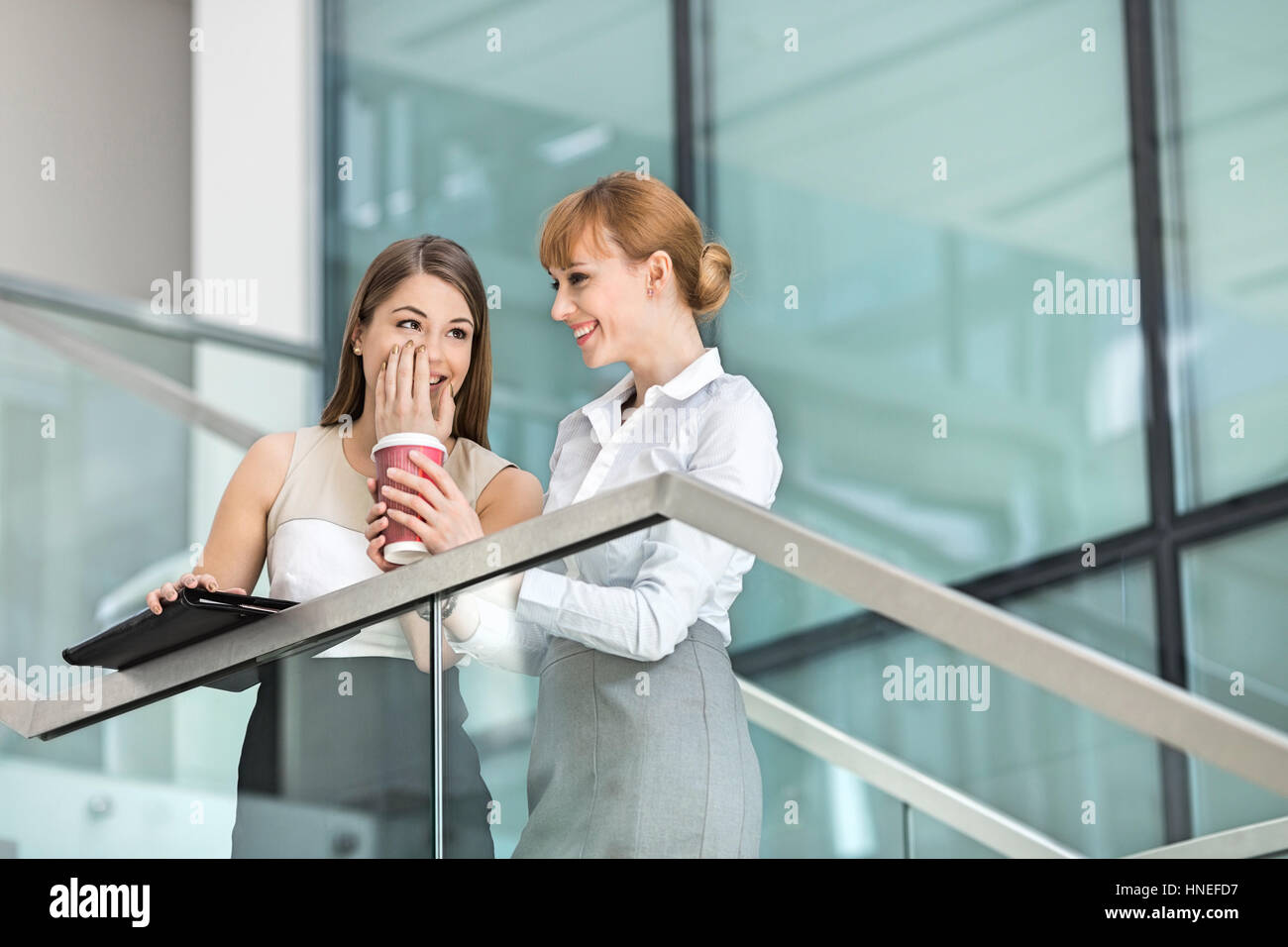 Geschäftsfrauen Klatsch mit Kaffee auf die Schritte im Büro Stockfoto