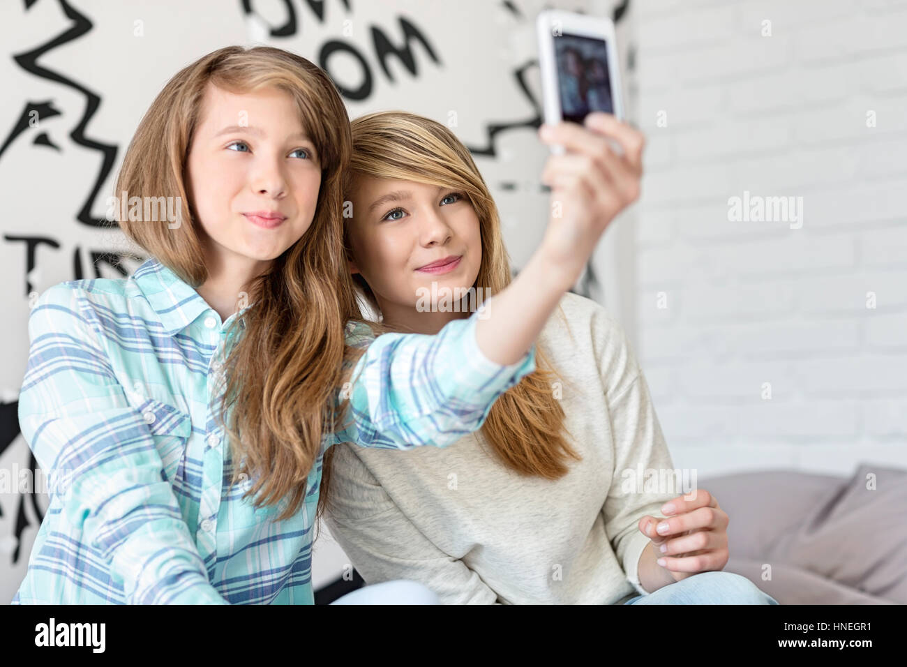 Nette Schwestern fotografieren mit Ihrem Smartphone zu Hause Stockfoto
