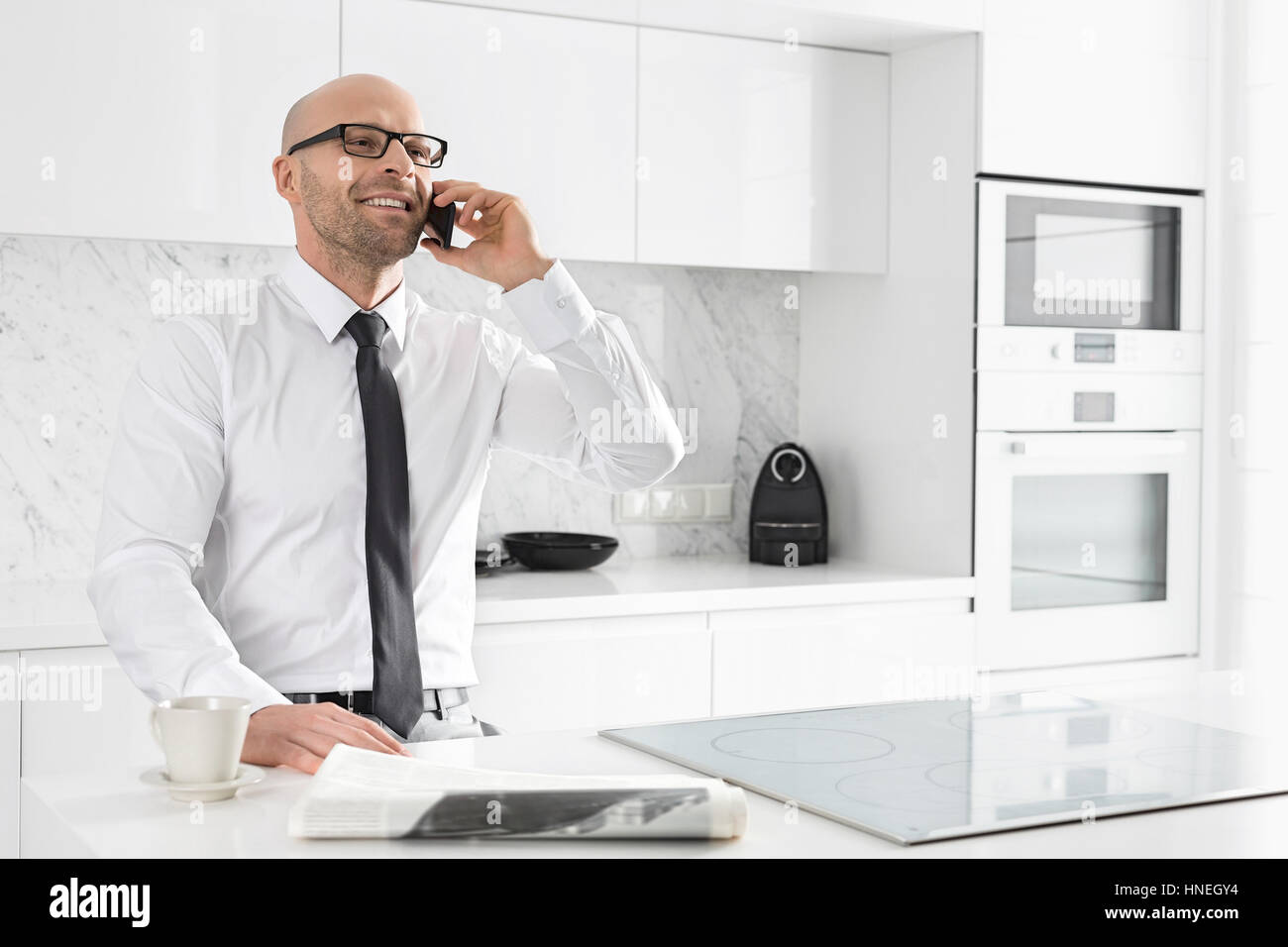 Mitte adult Geschäftsmann auf Abruf zu Küchentheke Stockfoto