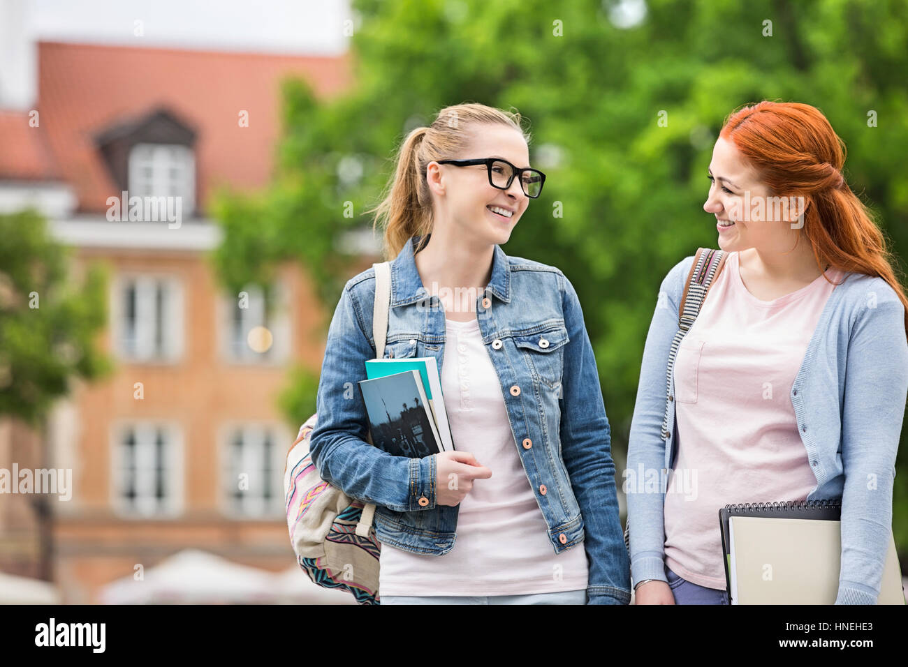Glückliche junge weibliche College-Freunde walking im freien Stockfoto