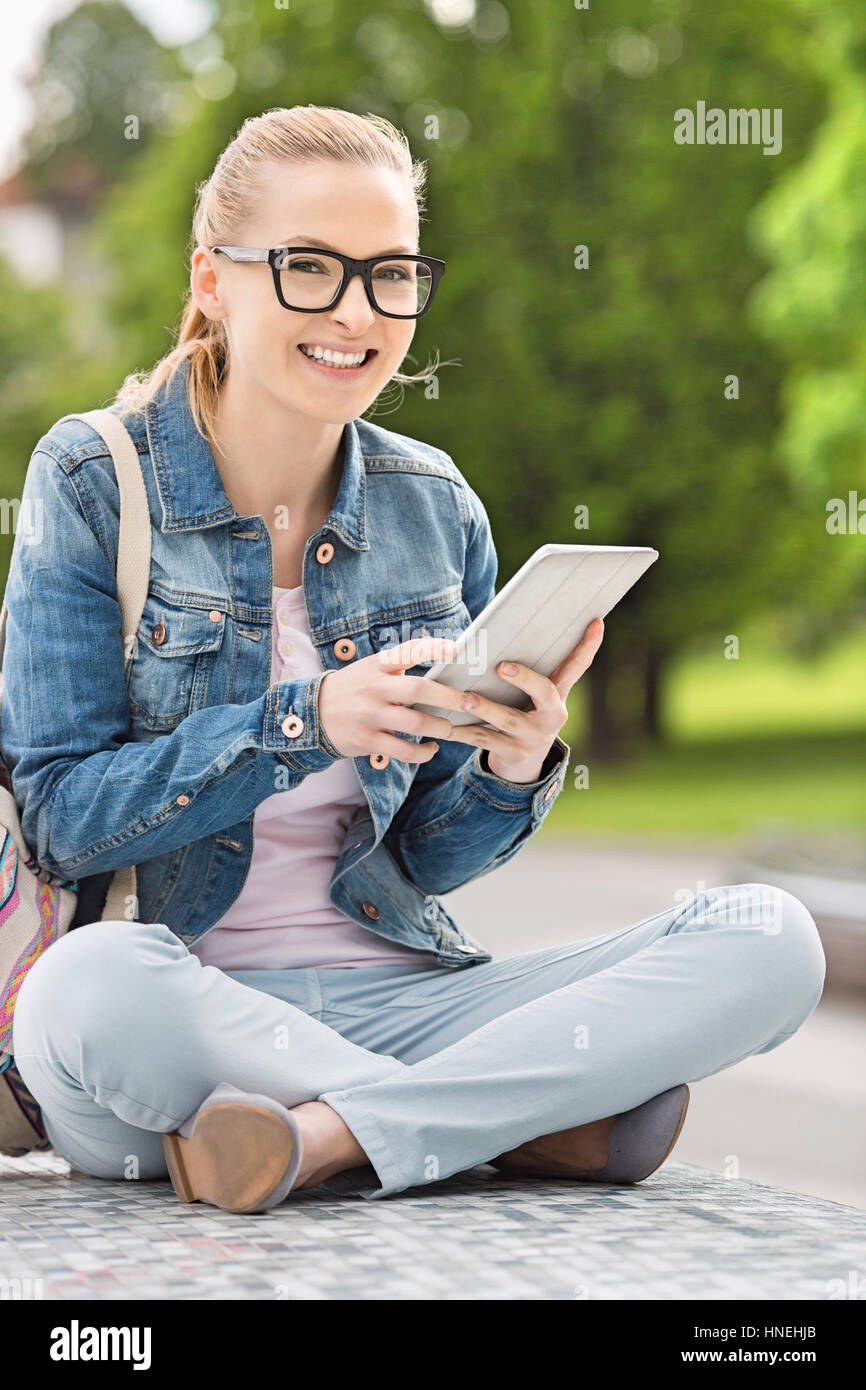 In voller Länge Portrait von lächelnden jungen weiblichen College-Student mit Tablet PC im park Stockfoto