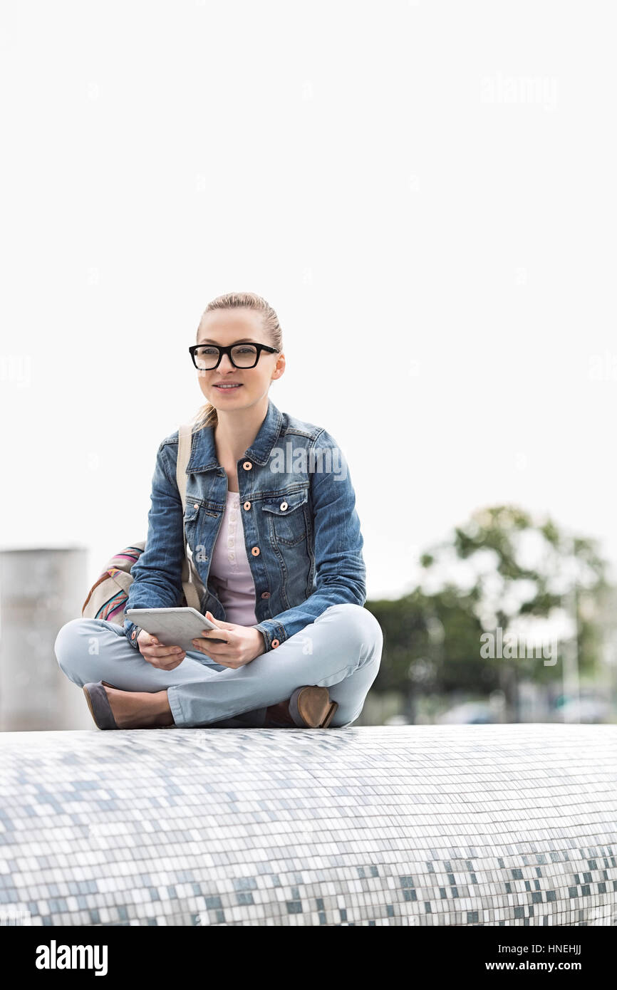 Gesamte Länge der junge weibliche Studentin mit digital-Tablette im park Stockfoto