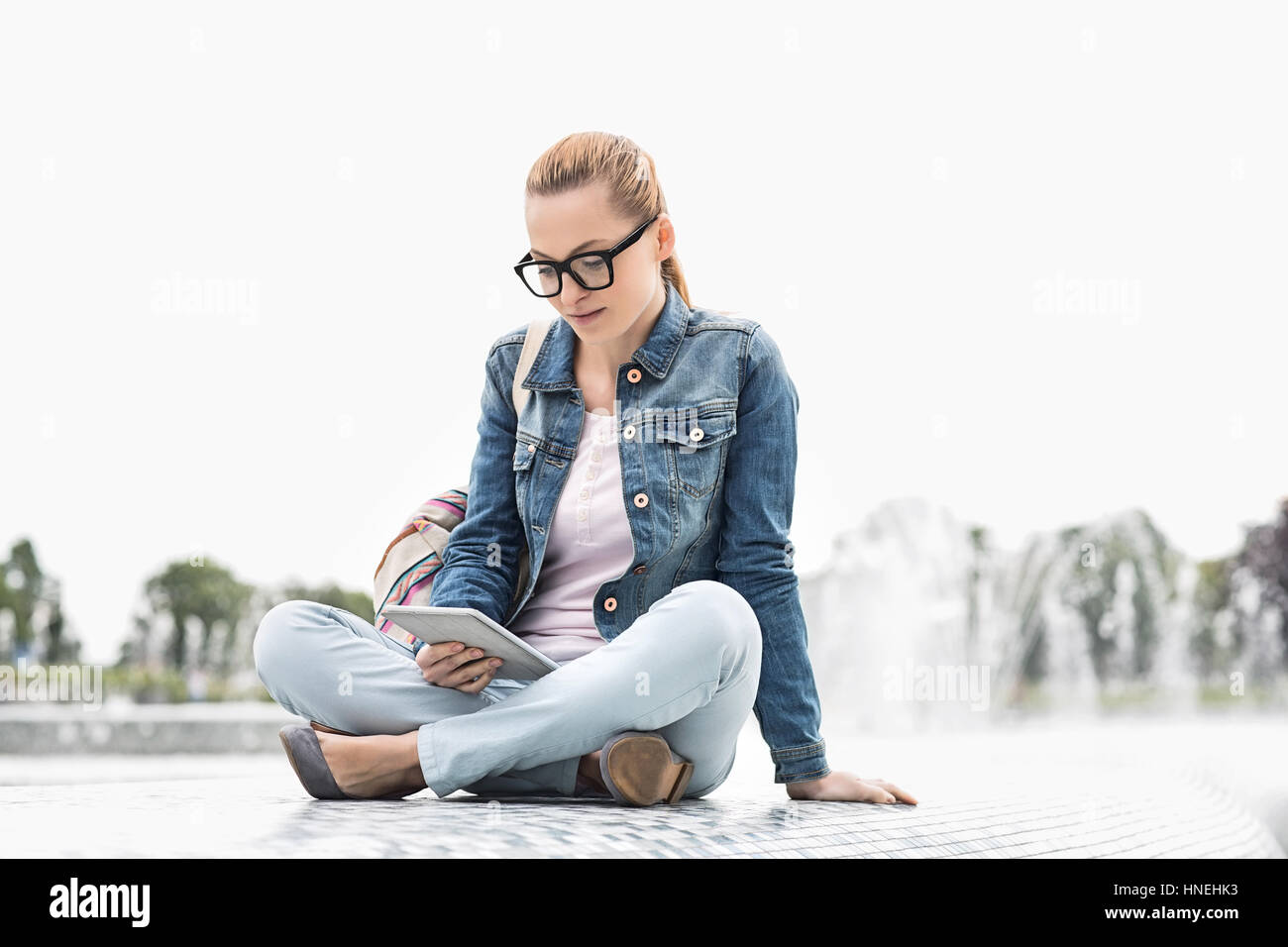 Voller Länge junge weibliche College-Studentin, die mit digital-Tablette im park Stockfoto