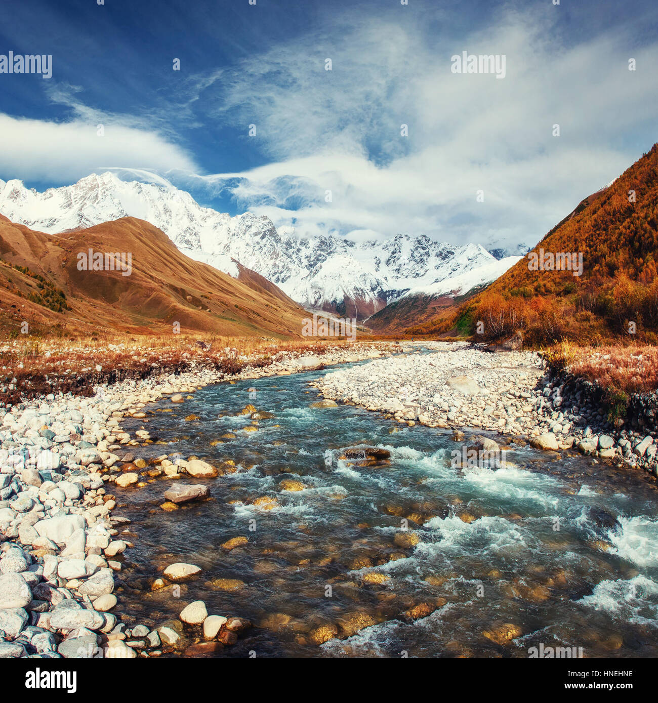 Verschneite Berge und laut Bergfluss Stockfoto