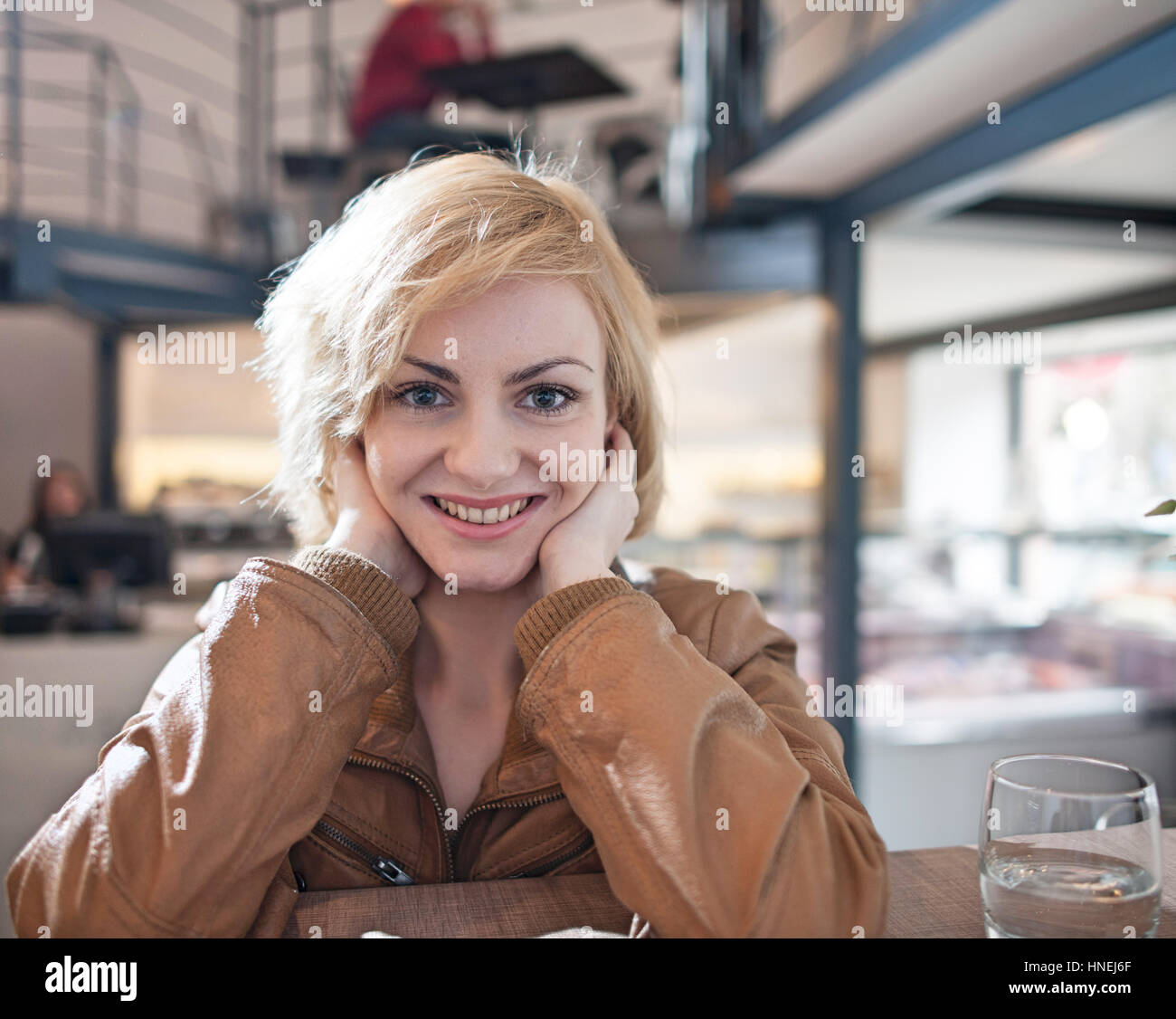 Porträt der schönen jungen Frau lächelnd in café Stockfoto