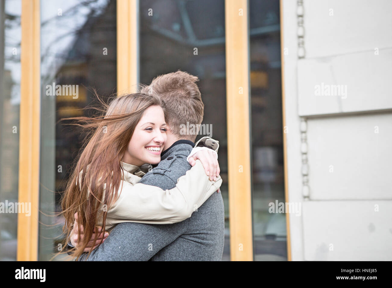 Seitenansicht des romantischen Paares umarmen vor café Stockfoto