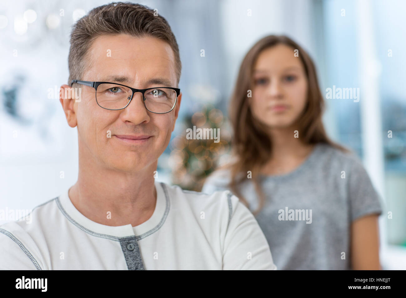 Porträt von lächelnden Mann mit Tochter im Hintergrund zu Hause stehen Stockfoto