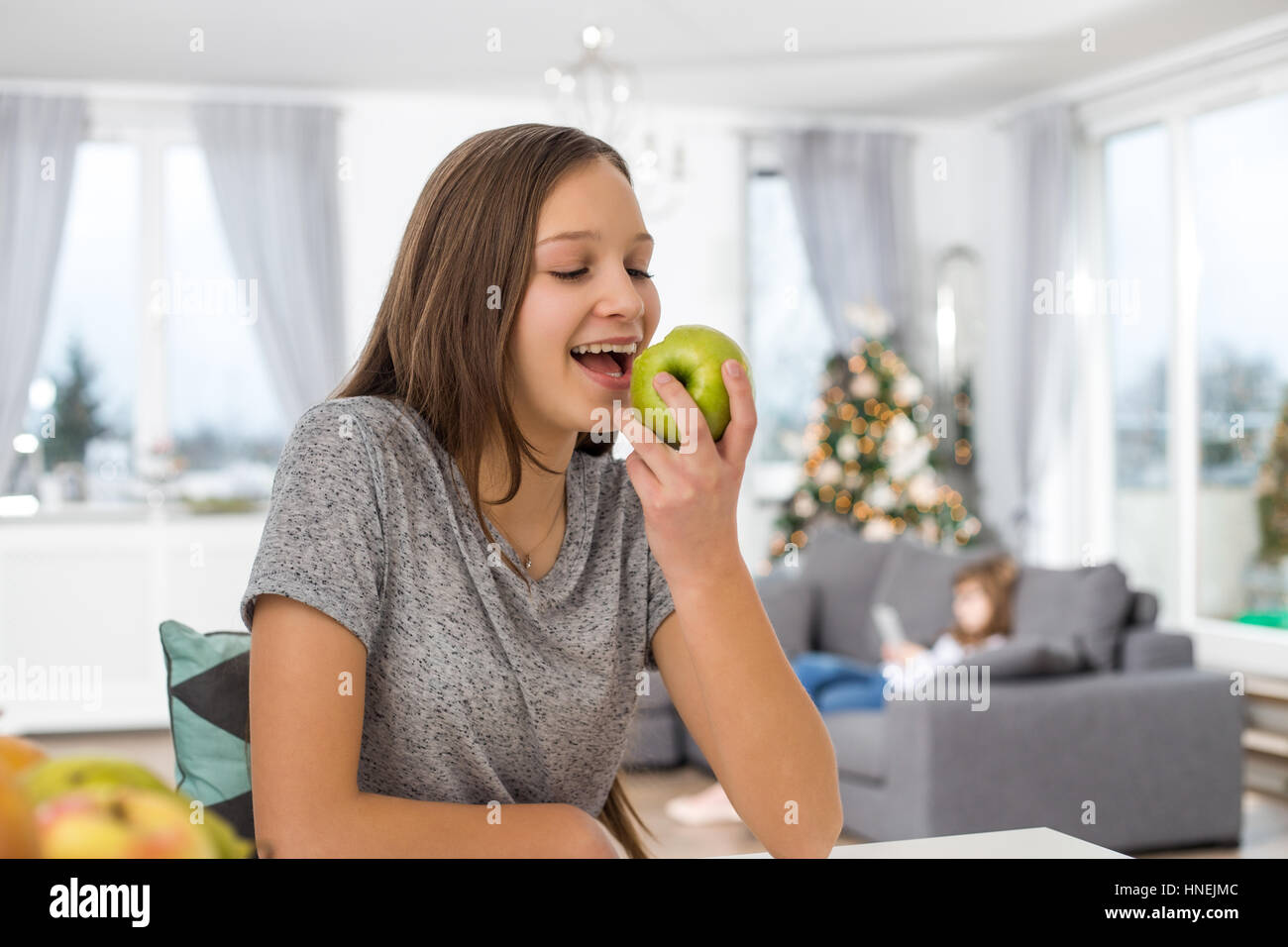 Glückliches Mädchen essen Apfel zu Hause Stockfoto