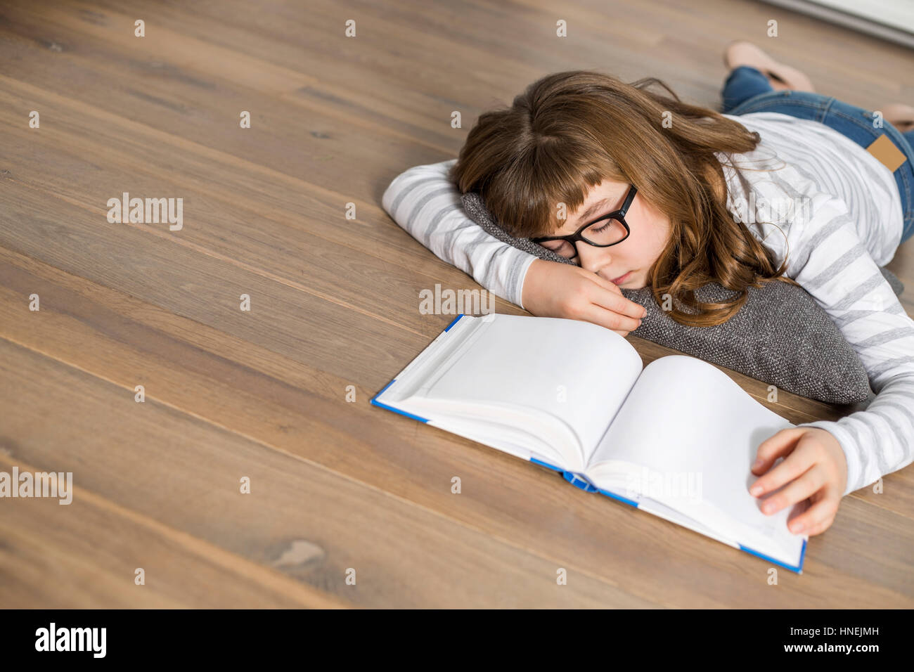Erhöhte Ansicht von Teenager-Mädchen schlafen während des Studiums auf Etage Stockfoto