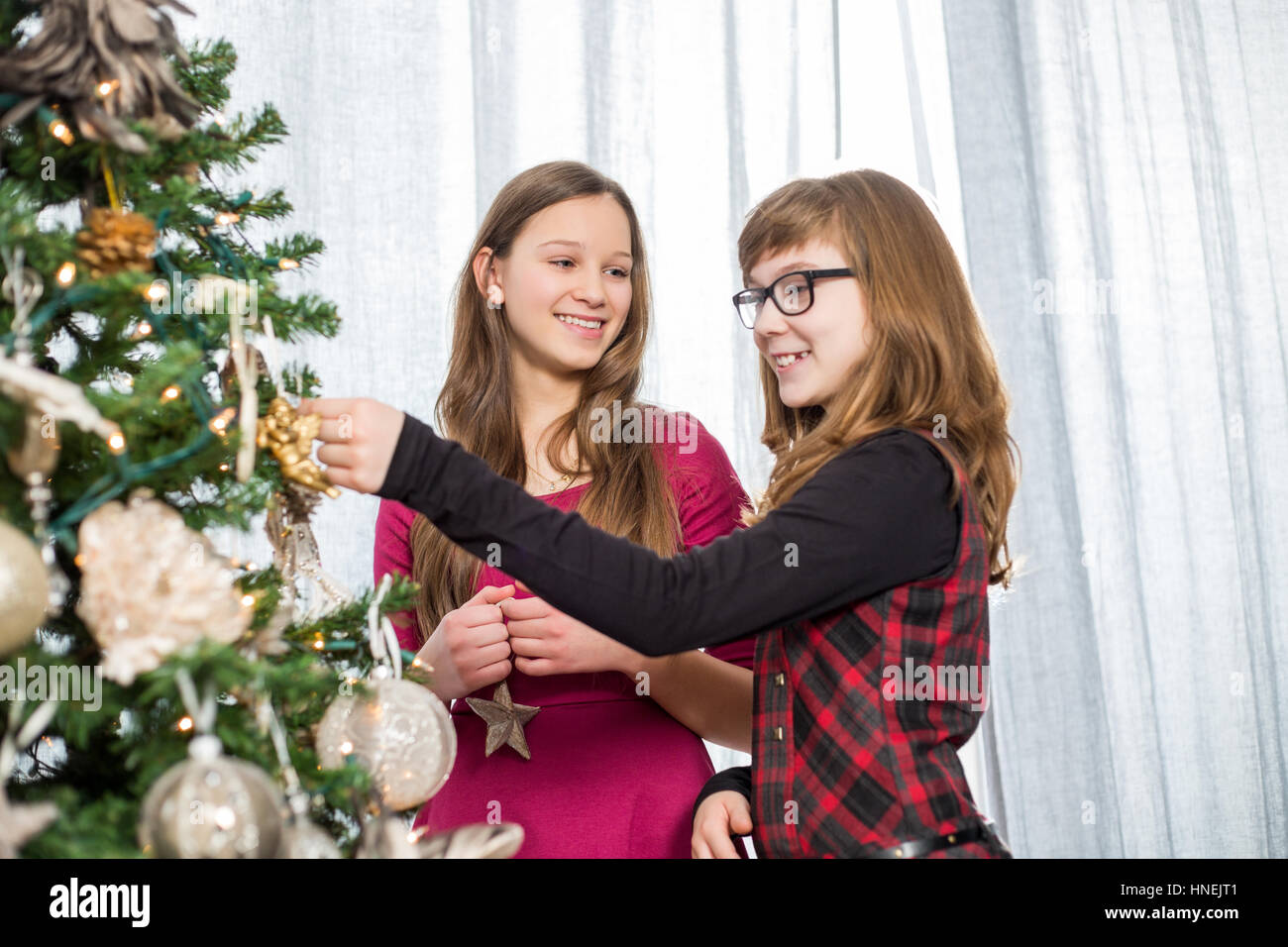 Schwestern, die Dekoration am Weihnachtsbaum zu Hause Stockfoto