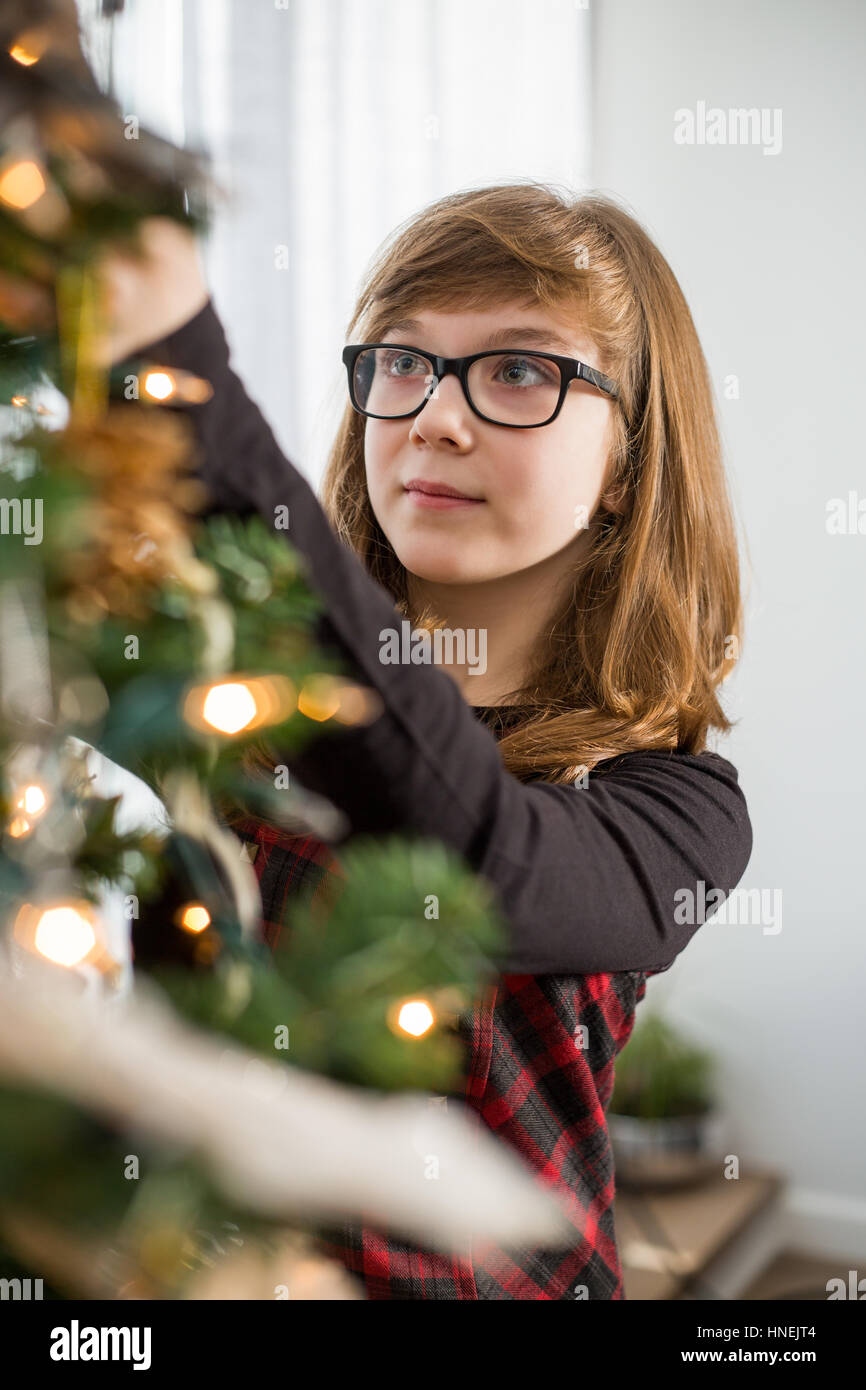 Teenager-Mädchen schmücken Weihnachtsbaum zu Hause Stockfoto