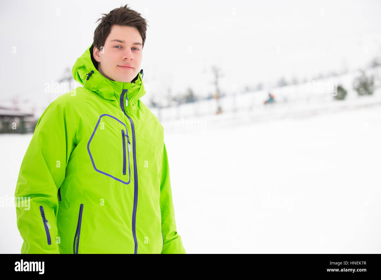 Porträt des jungen Mann mit Kapuzenjacke im Schnee Stockfoto
