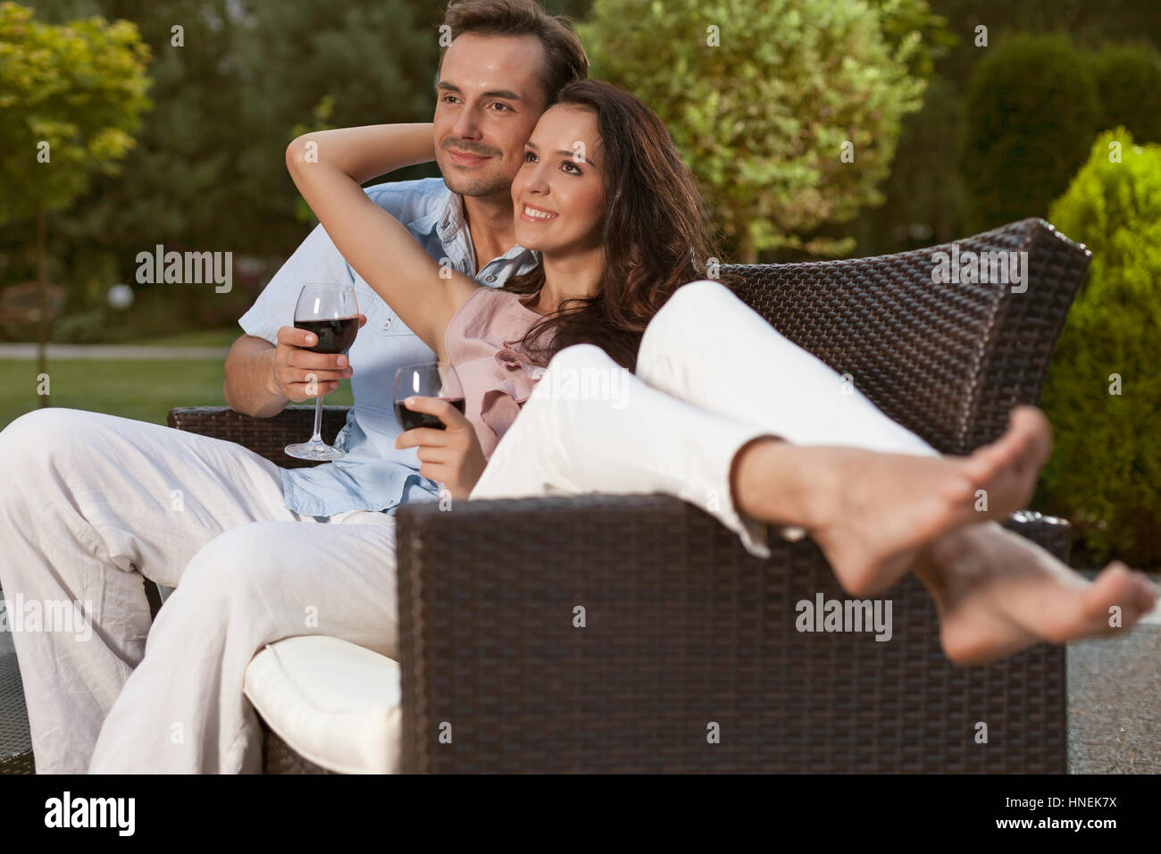 Romantische junges Paar auf Sessel wegschauen im park Stockfoto