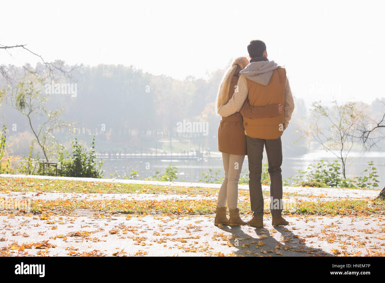 Rückansicht des Paares Blick auf See im Park im Herbst Stockfoto