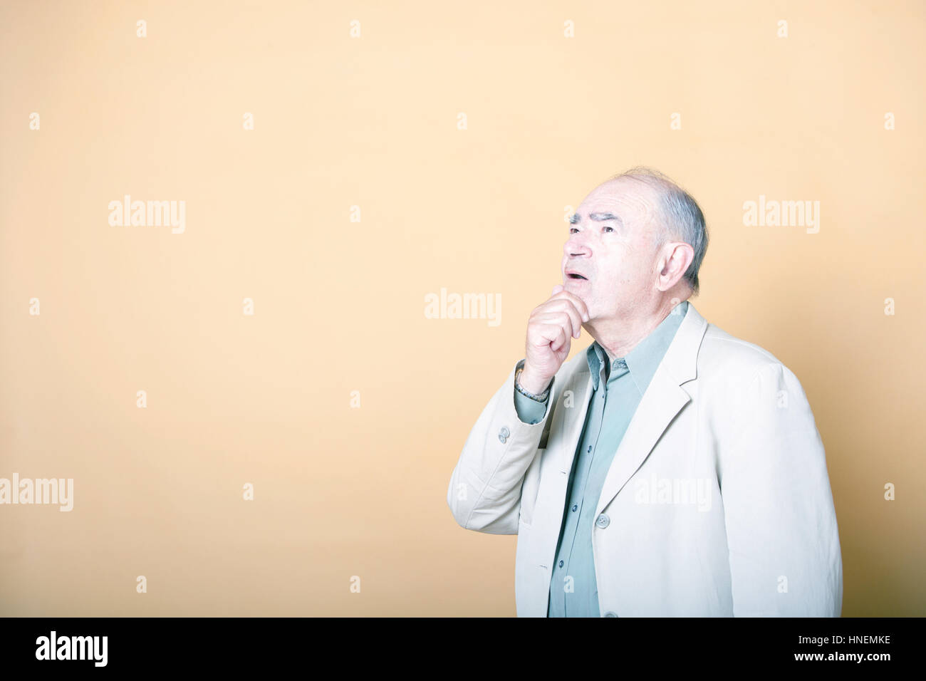 Älteren Erwachsenen Mannes mit der Hand am Kinn blickte neugierig Stockfoto