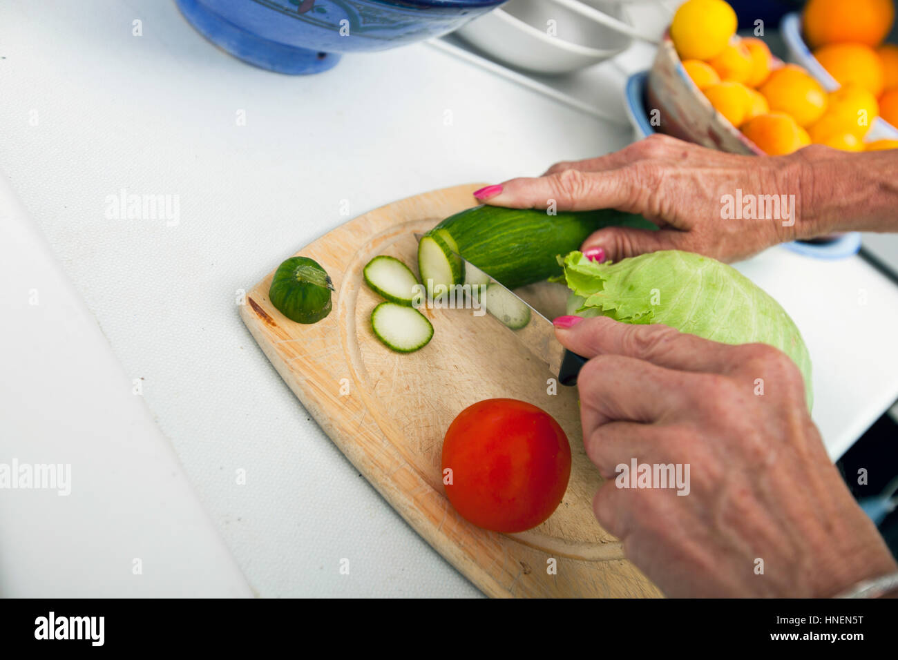 Bild der senior Frau Schneiden von Gemüse auf Schneidebrett in der Küche zugeschnitten Stockfoto