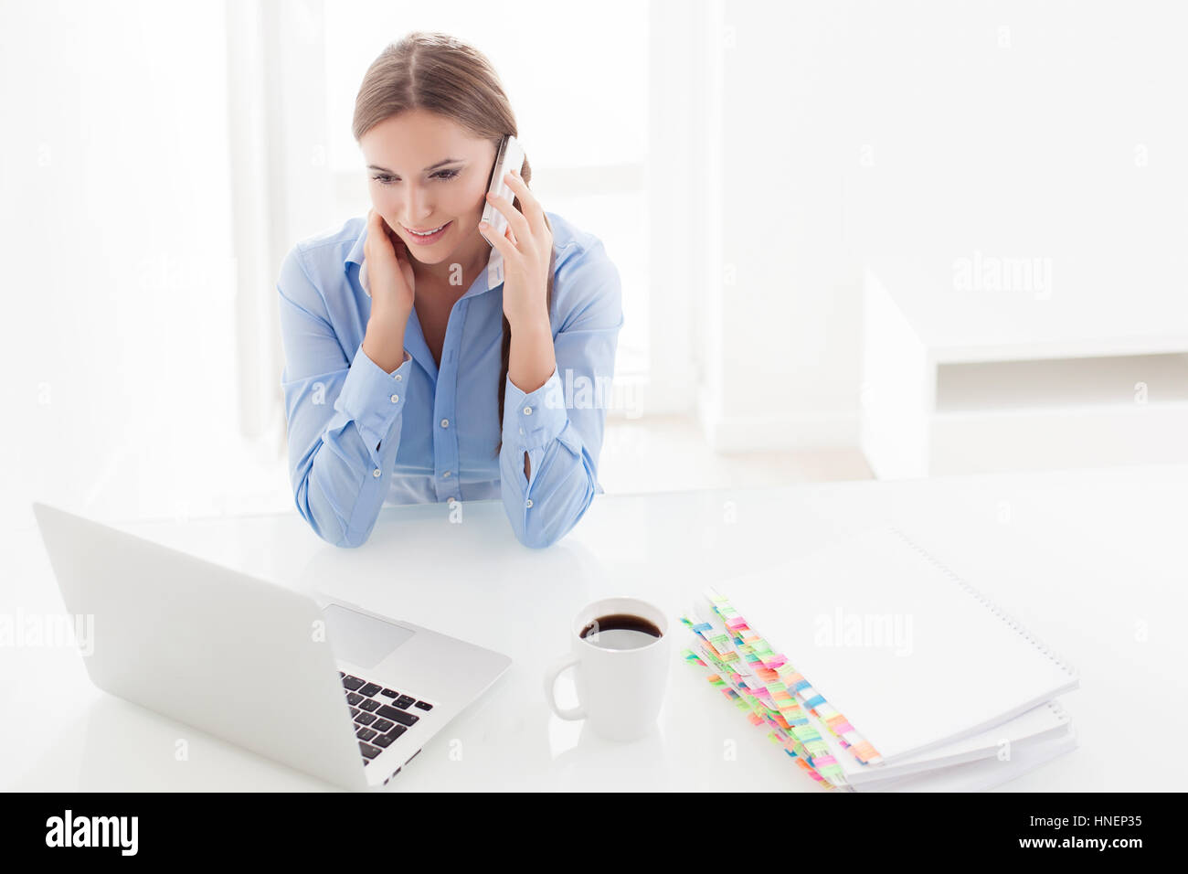 Frau mit Handy und Computer zu betrachten Stockfoto