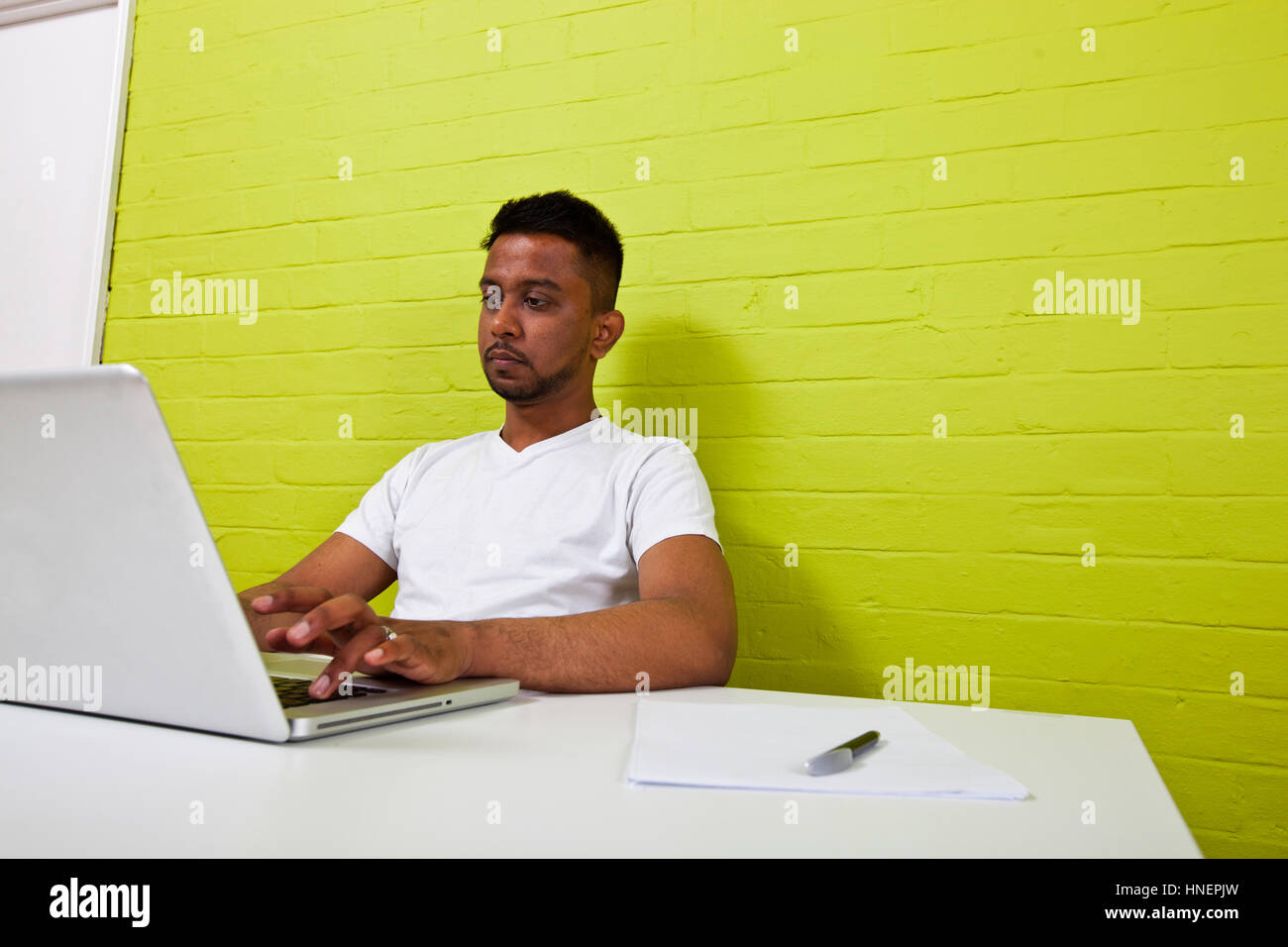 Junge indische Mann an seinem Computer arbeiten Stockfoto