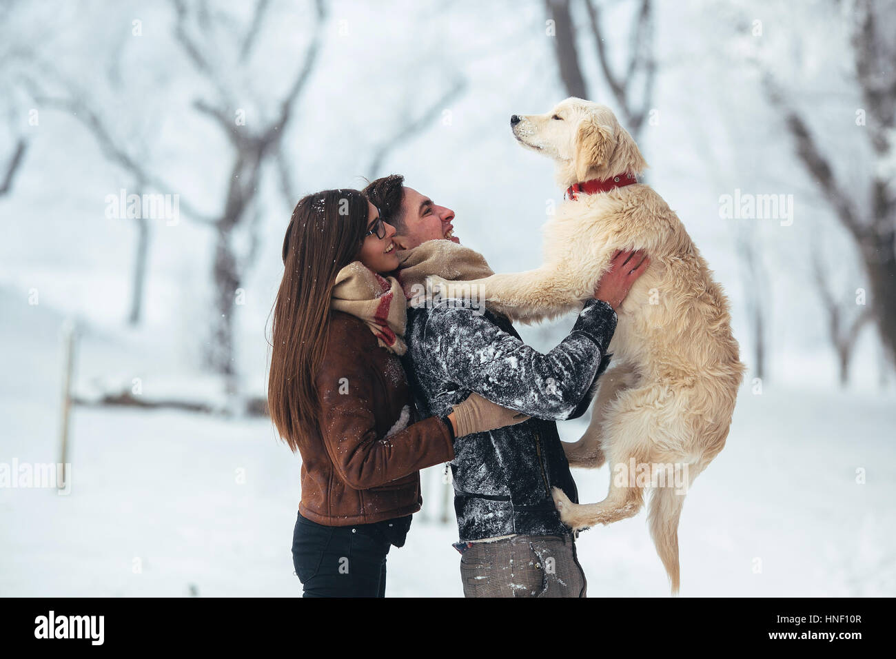 Junge Paare, die Spaß in Winter park Stockfoto