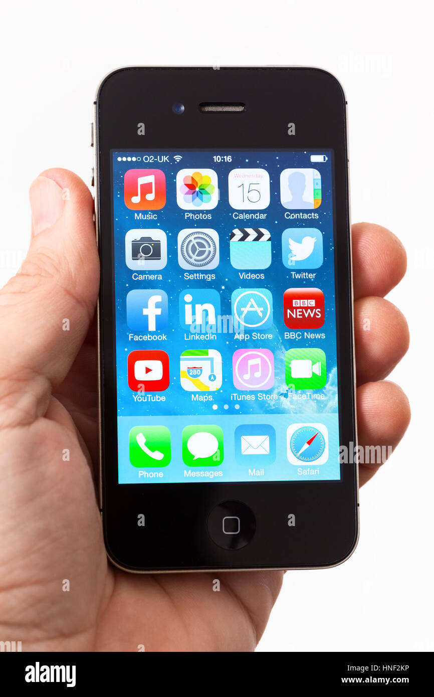 BATH, Großbritannien - 15. Januar 2014: Die Hand eines Mannes mit einem Apple iPhone 4 s mit iOS 7-Software installiert. Gedreht in Nahaufnahme vor einem einfarbigen Hintergrund mit v Stockfoto