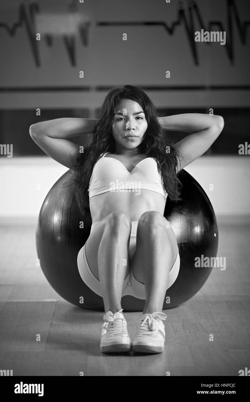 Mädchen, stützte sich auf Fitness-Ball im Fitness-Studio schwarz und weiß Farben Stockfoto