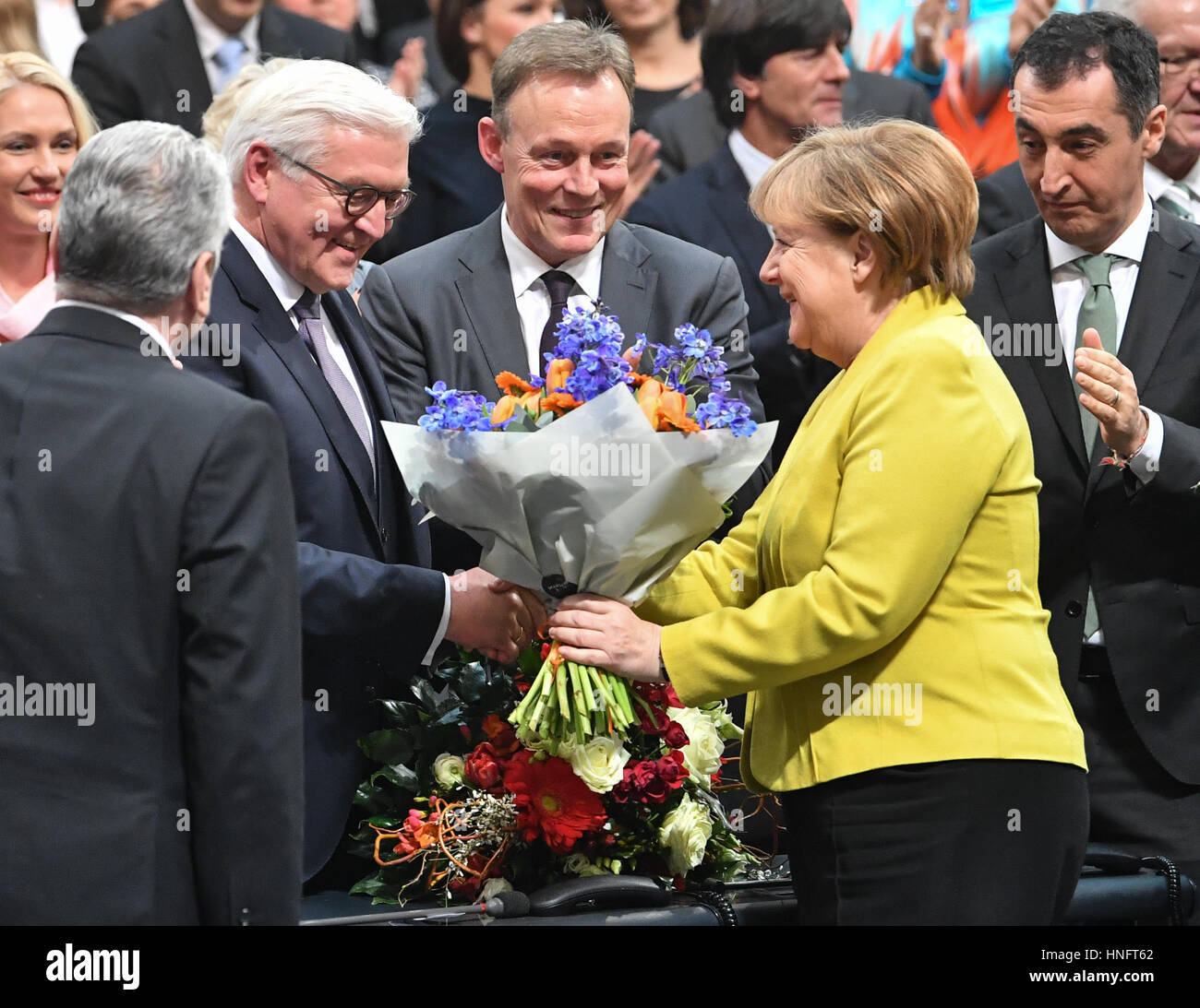 Berlin, Deutschland. 12. Februar 2017. Bundeskanzlerin Angela Merkel die Hände der gewählte Bundespräsident Frank-Walter Steinmeier einen Blumenstrauß der Blumen nach den Präsidentschaftswahlen am Deutschen Reichstags Gebäude in Berlin, Deutschland, 12. Februar 2017. Die Bundesversammlung für 61-jährige mit 931 aus 1239 stimmen, er ist jetzt der offizielle Nachfolger von Joachim Gauck gestimmt. Foto: Bernd Von Jutrczenka/Dpa/Alamy Live News Stockfoto