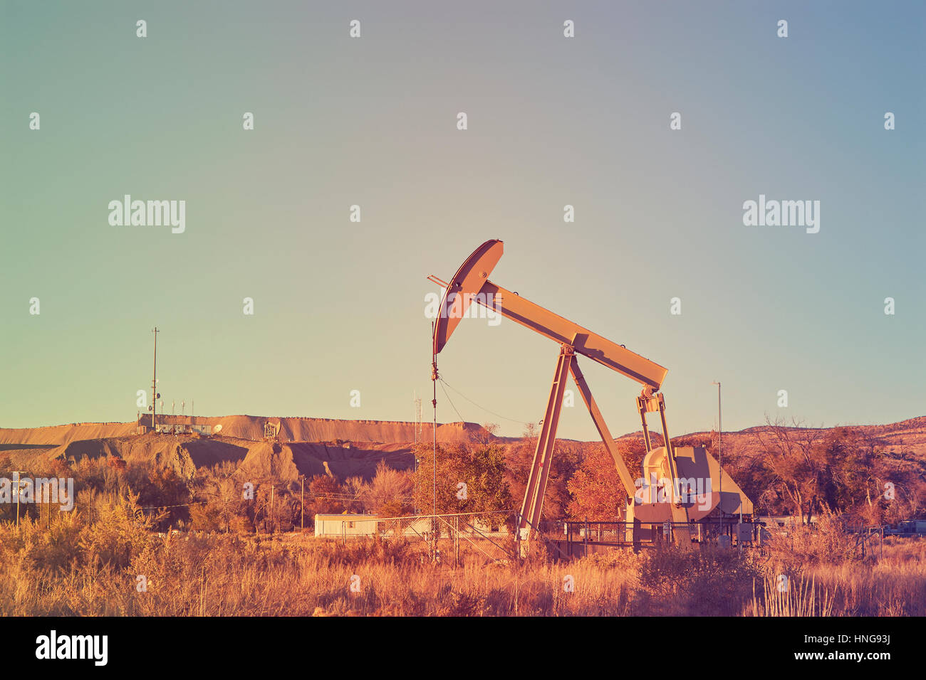 Retro-Farbe getönt eine alte Ölpumpe bei Sonnenuntergang, industrielle Ausrüstung. Stockfoto