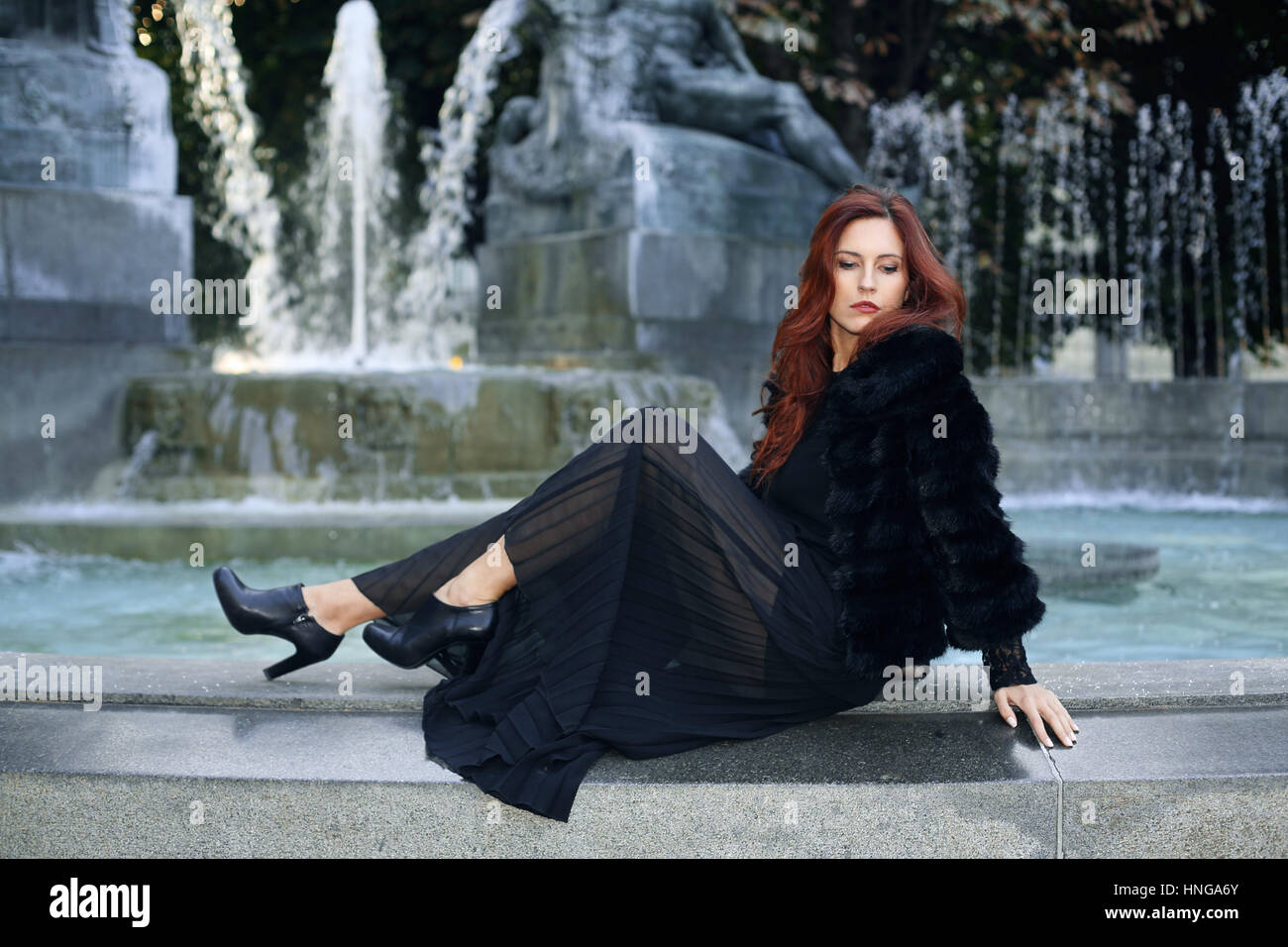 Schöne Frau posiert in der Nähe von historischen Brunnen. Weiche helle Farben Stockfoto