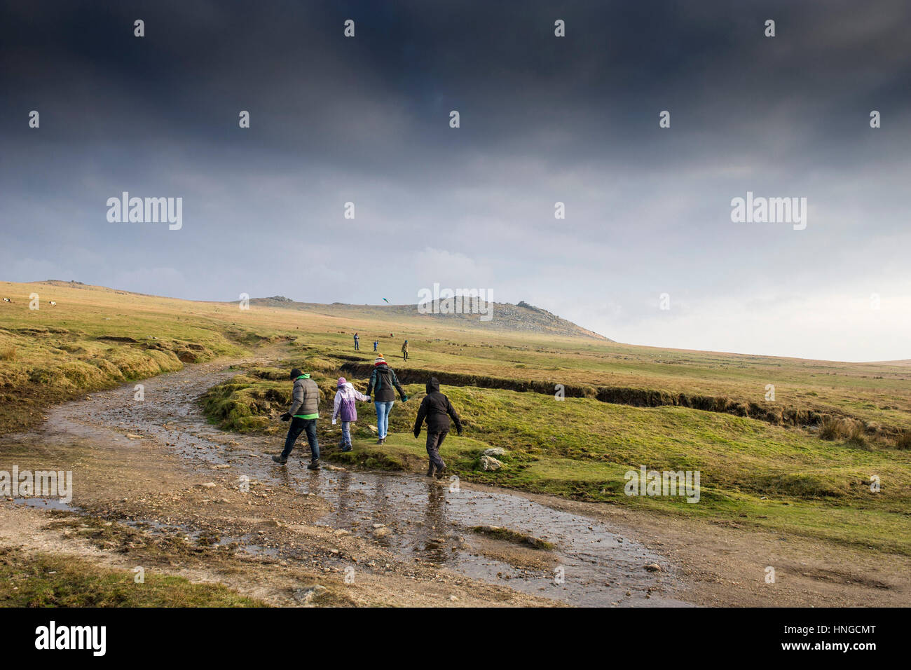 Eine Familie, die zu Fuß auf einem schlammigen Wanderweg auf grobe Tor, Bodmin Moor, Cornwall. Stockfoto