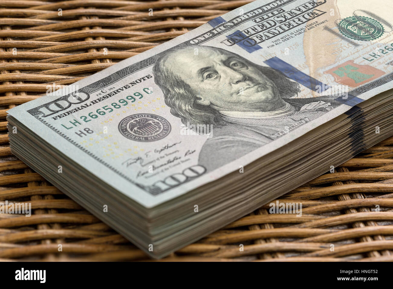 Stapel von Vereinigte Staaten von Amerika USD 100 100 US-Dollar US-Notenbank Hinweis in einem Stapel auf Wicker Hintergrund Stockfoto