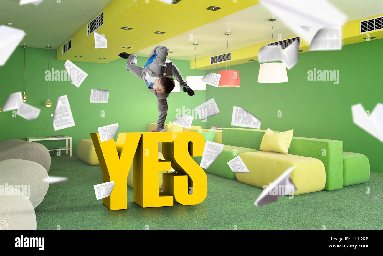 Fröhliche Jungunternehmer tanzen in seinem Büro. Mixed-media Stockfoto