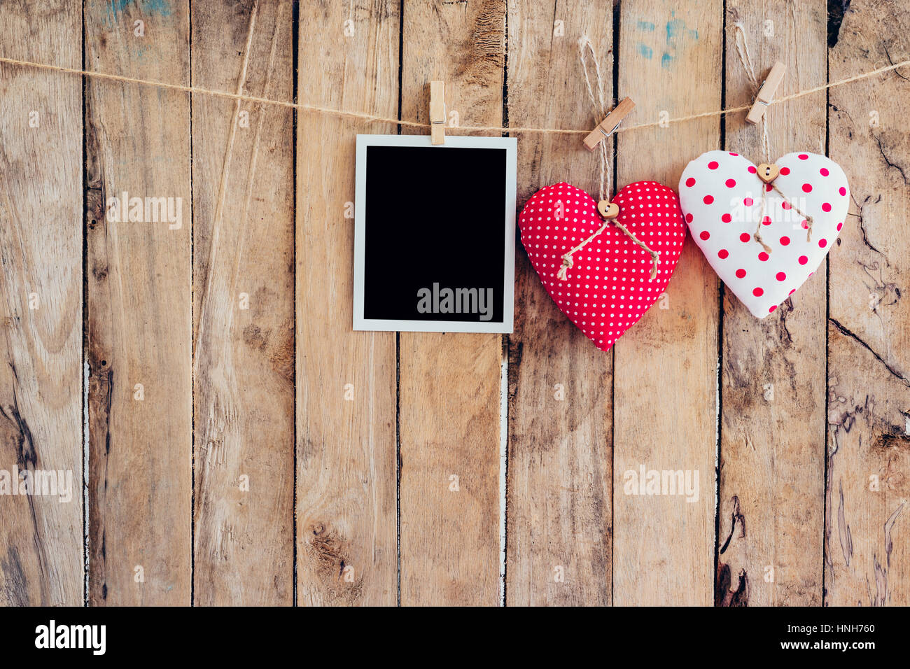 Zwei Herzen und Foto Rahmen hängen, Wäscheleine Seil mit hölzernen Hintergrund. Stockfoto