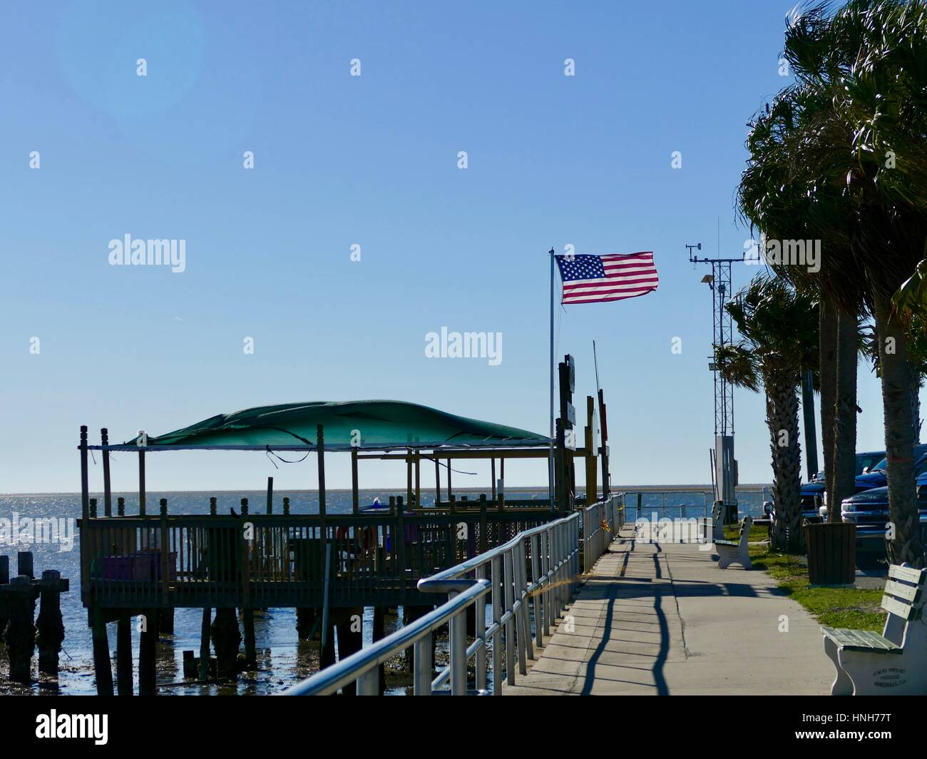 Amerikanische Flagge an den Docks weht eine steife Brise, Cedar Key, Florida, USA Stockfoto