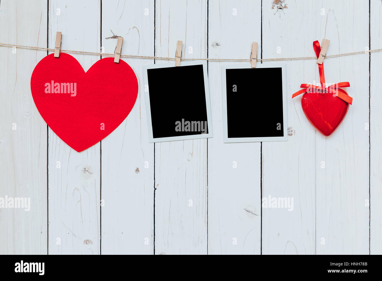 Zwei Foto-Frame leer und roten Herzen hängen weiße Holz Hintergrund mit Raum Stockfoto