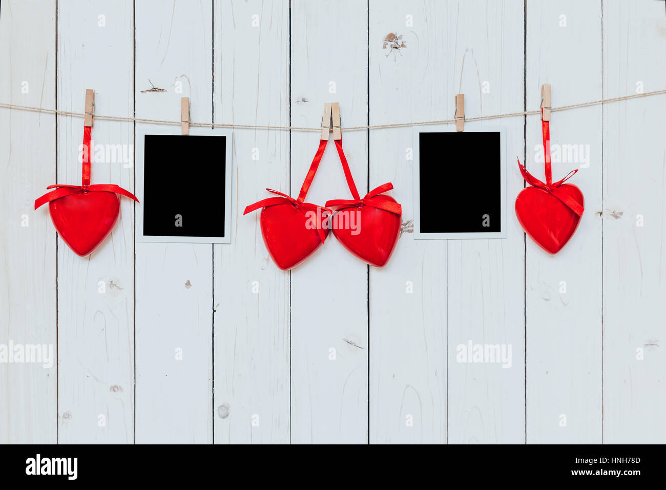 Zwei Foto-Frame leer und roten Herzen hängen weiße Holz Hintergrund mit Raum Stockfoto