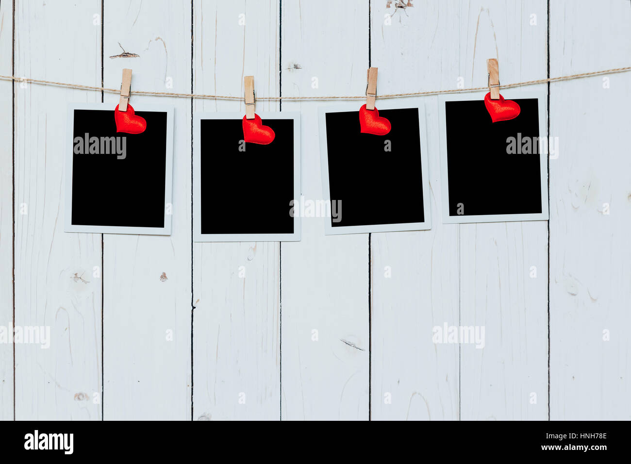 Vier Foto-Frame leer und roten Herzen hängen weiße Holz Hintergrund mit Raum Stockfoto
