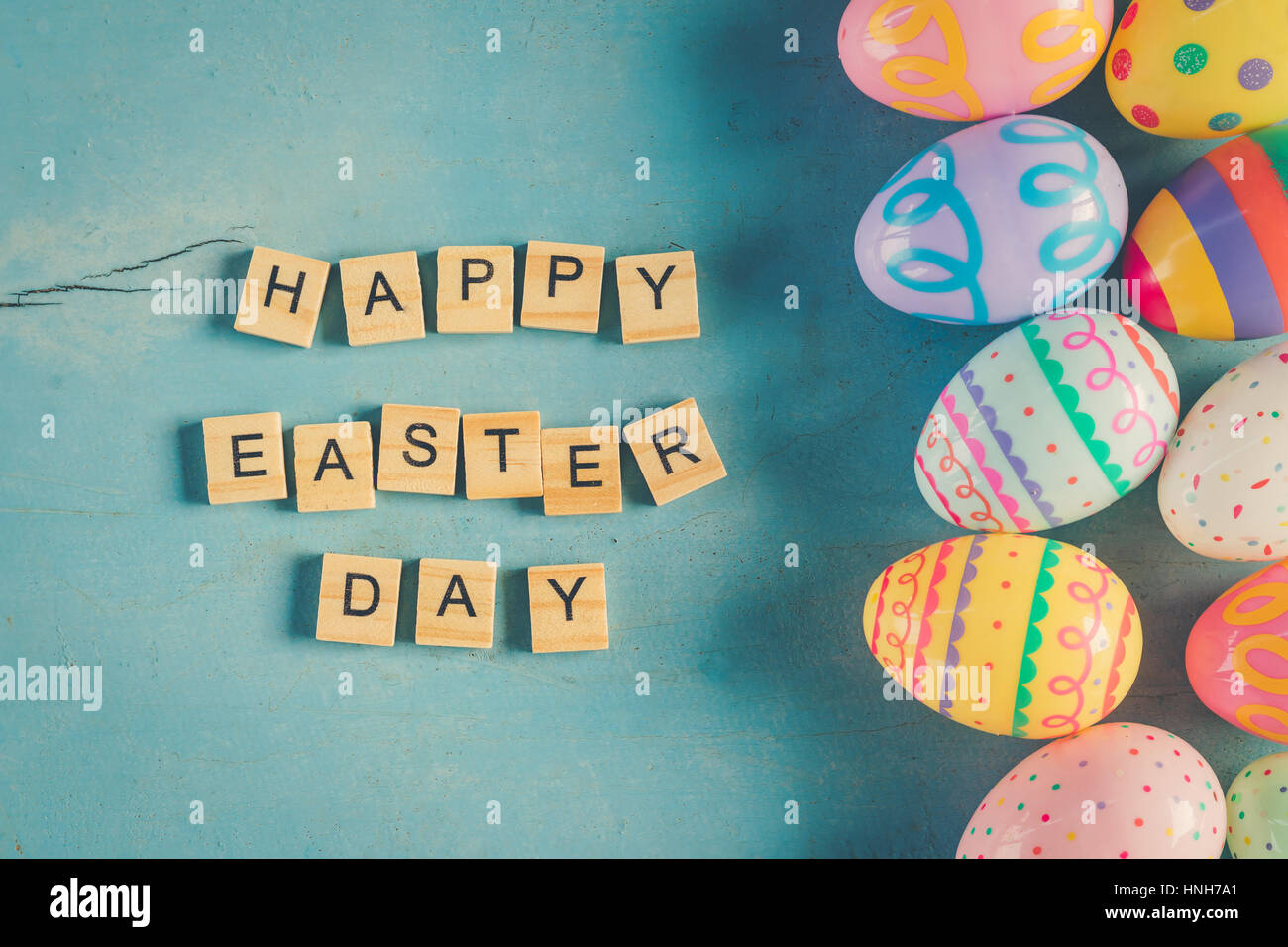 Bunte Ostereier und Holz Text Happy Easter Day auf blau Pastell Farbe Holz Hintergrund mit dem Raum. Stockfoto