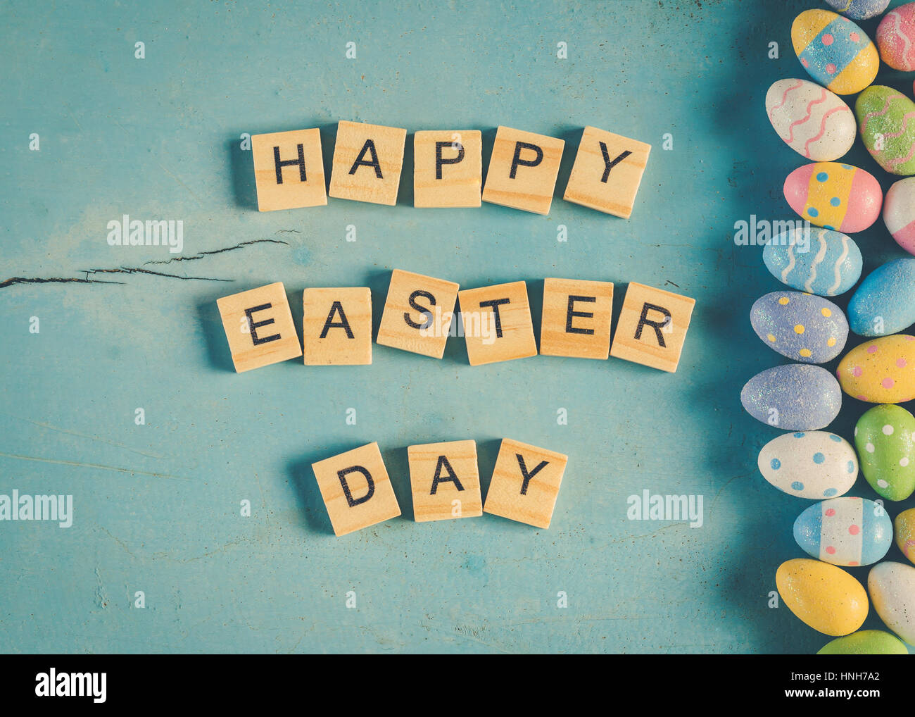Bunte Ostereier und Holz Text Happy Easter Day auf blau Pastell Farbe Holz Hintergrund mit dem Raum. Stockfoto