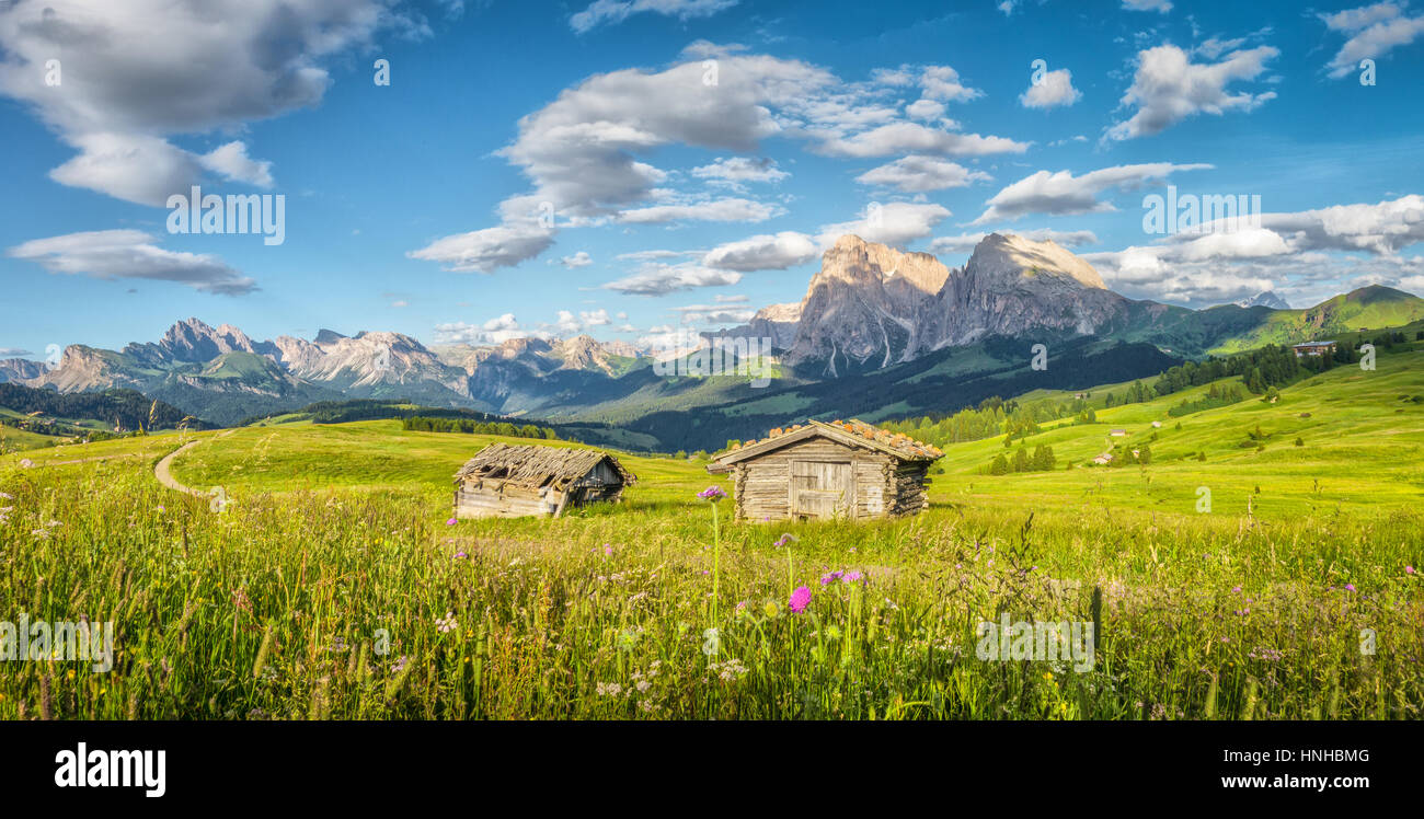 Idyllische Berglandschaft der Dolomiten mit traditionellen alten Chalets und Wiesen im schönen Abendlicht bei Sonnenuntergang, Alpe di Siusi, Italien Stockfoto