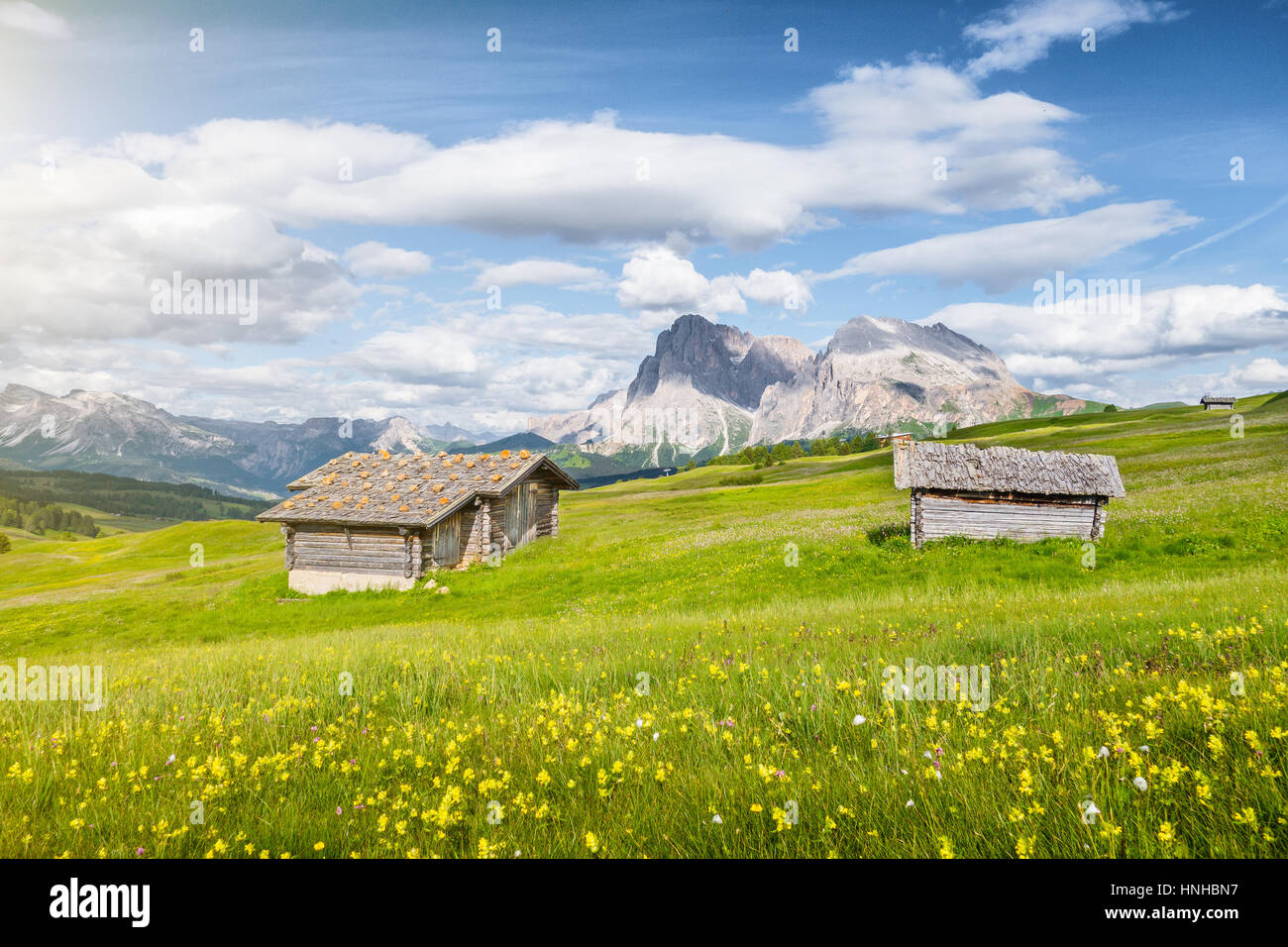 Schöne Aussicht auf die idyllische Bergkulisse der Alpen mit traditionellen alten Chalets und frischen grünen Wiesen an einem sonnigen Tag mit blauem Himmel und Wolken Stockfoto