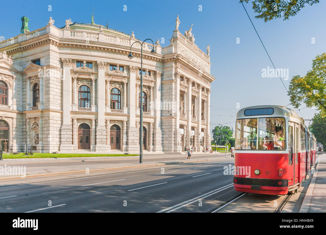 Klassische Ansicht der berühmten Wiener Ringstraße mit historischen Burgtheater (Imperial Court Theatre) und traditionelle rote elektrische Straßenbahn, Wien, Österreich Stockfoto