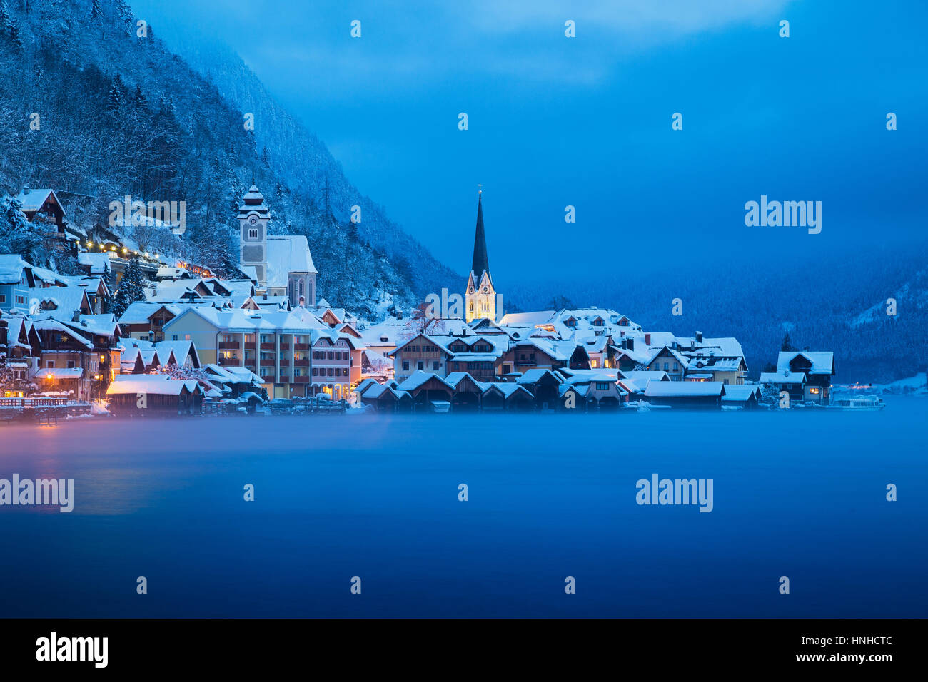 Klassische Postkartenblick auf berühmte Hallstätter See Stadt in den Alpen in der mystischen Dämmerung in der Morgendämmerung an einem kalten, nebligen Tag im Winter, Salzkammergut, Österreich Stockfoto
