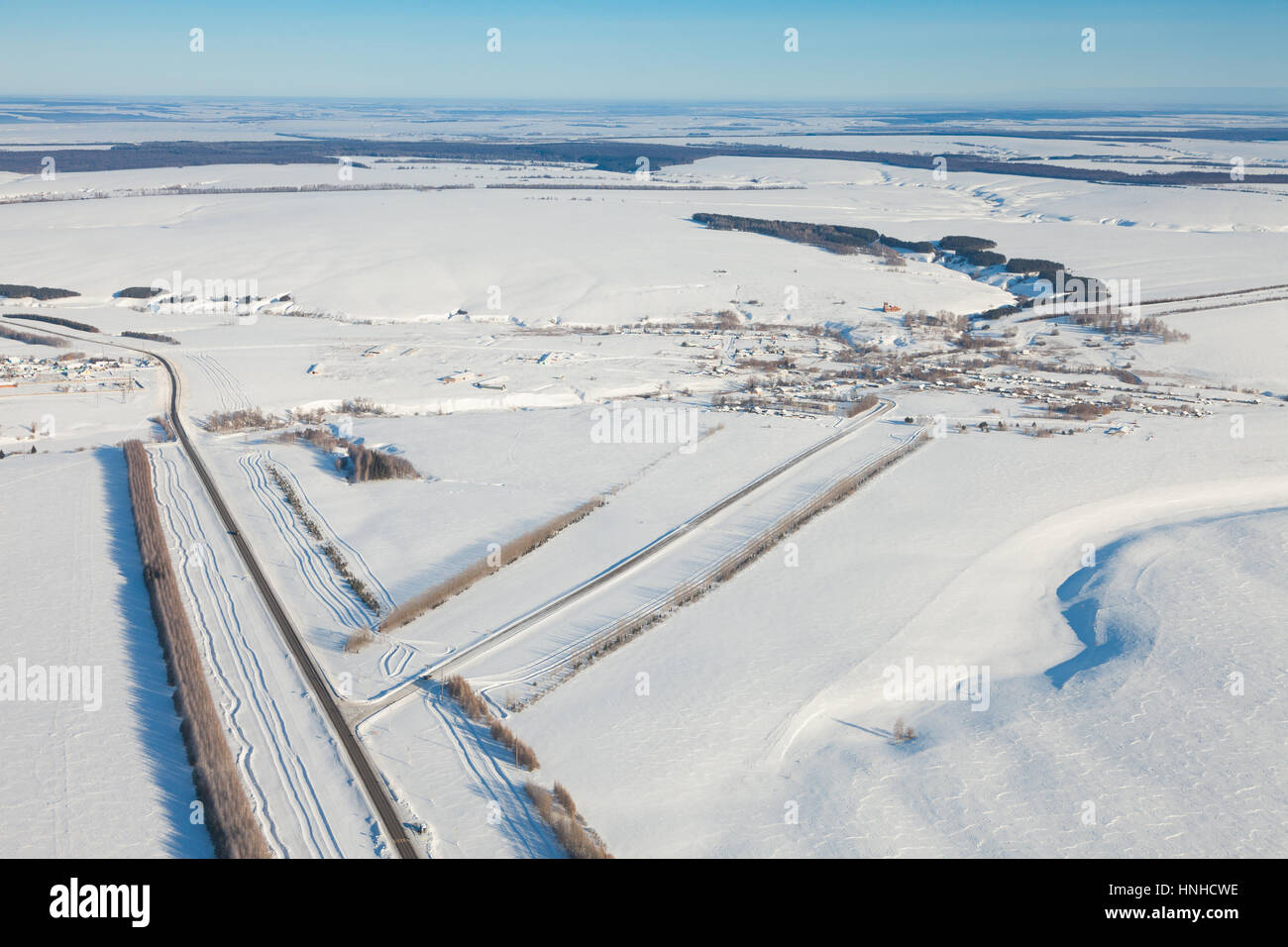 Luftaufnahme über schneebedecktes Feld und Straße Stockfoto