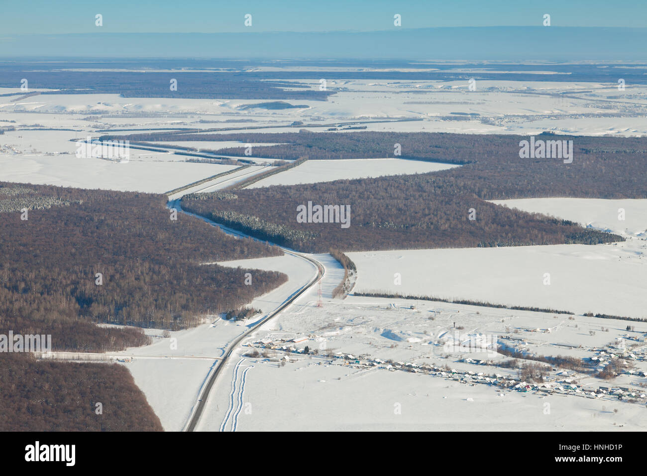 Luftaufnahme über schneebedecktes Feld und Straße Stockfoto
