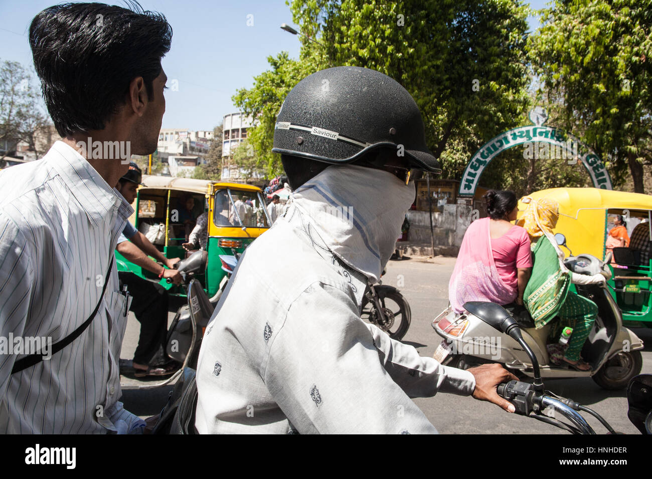 Verkehr, Motorräder, Roller, Umweltverschmutzung, Sozius, Passagiere, tragen, Gesicht, Masken, bedeckt, Rauch, Luftverschmutzung, Ahmedabad, Gujarat, Indien, Asien, asiatisch, Stockfoto