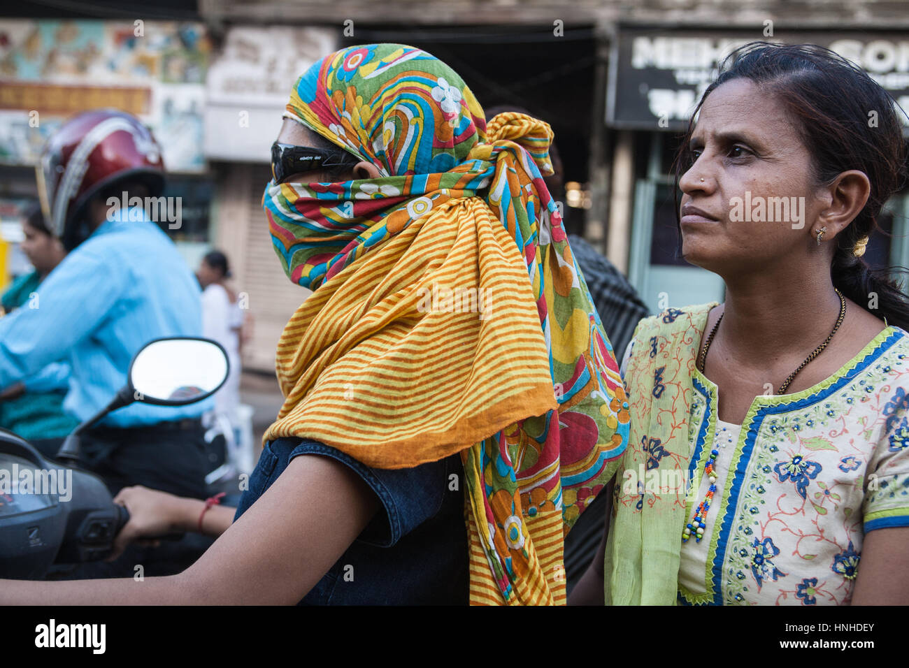 Verkehr, Motorräder, Roller, Umweltverschmutzung, Sozius, Passagiere, tragen, Gesicht, Masken, bedeckt, Rauch, Luftverschmutzung, Ahmedabad, Gujarat, Indien, Asien, asiatisch, Stockfoto