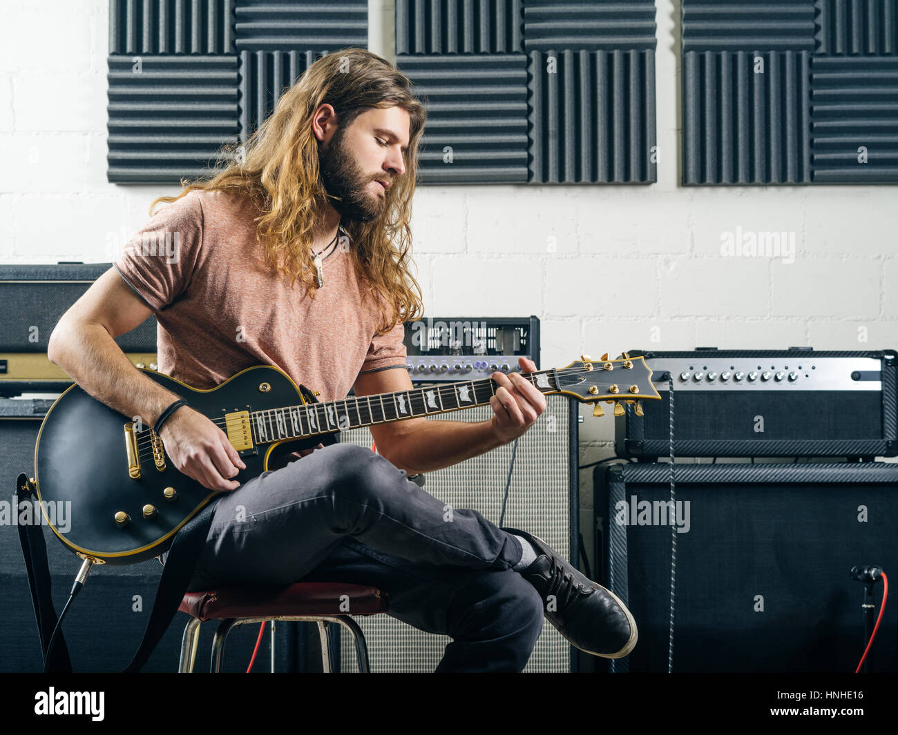 Foto eines attraktiven Mannes spielt e-Gitarre in einem Tonstudio. Stockfoto
