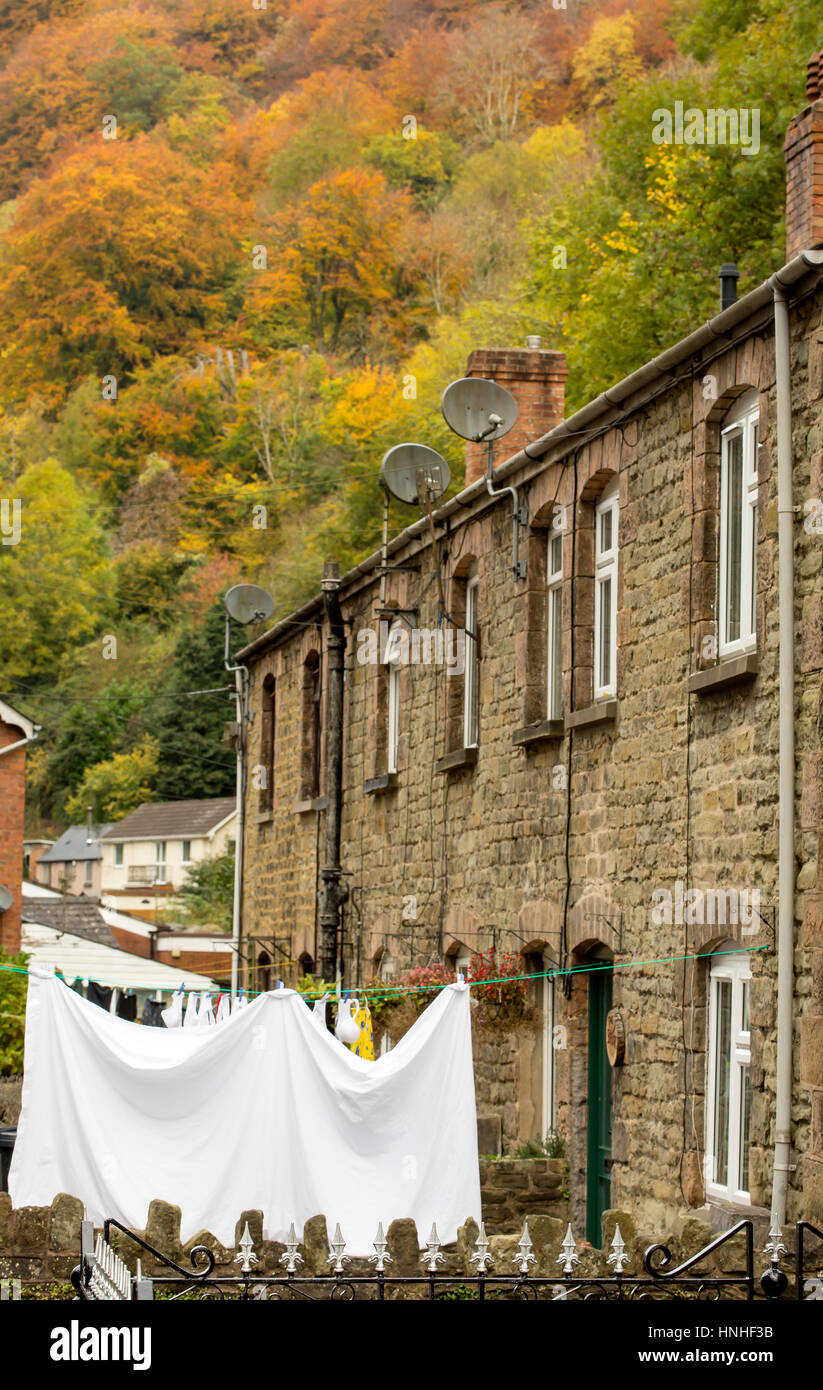 Herbst in einem Welsh-Tal. Eine steile Tal mit einem Dorf an der Unterseite ist bedeckt mit Herbstfärbung und gefüllt mit traditionellen Steinhäusern. Stockfoto
