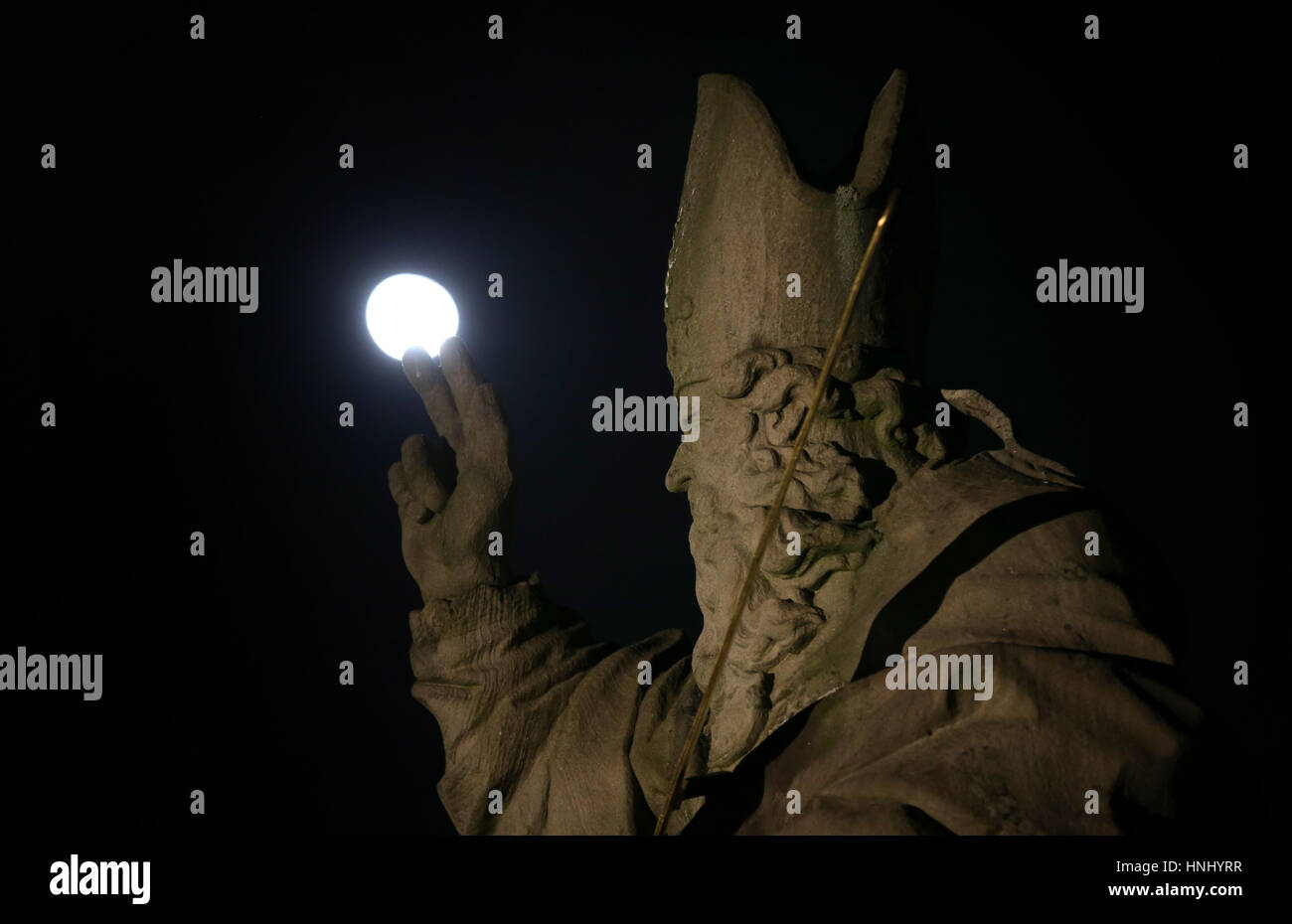 Der Mond hinter der Statue des Heiligen Kilian auf die Alte Mainbruecke Brücke in Würzburg, 13. Februar 2017 zu sehen. Foto: Karl-Josef Hildenbrand/dpa Stockfoto